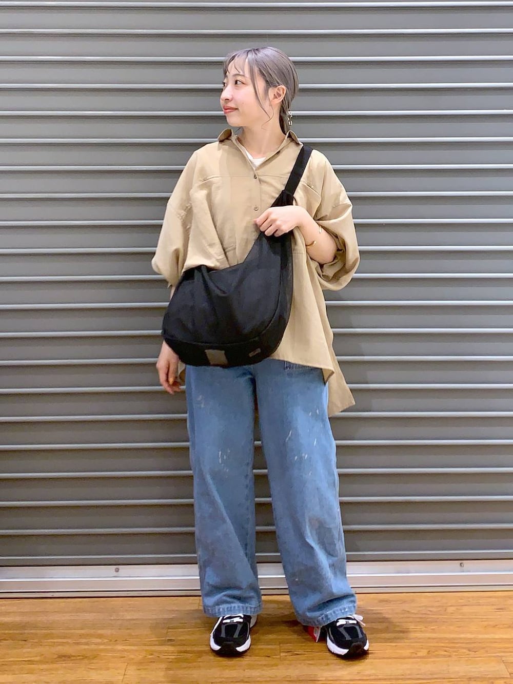 ブラック系のスニーカー、ブラック系のショルダーバッグ、ベージュ系のシャツ/ブラウスを着用したレディースの春コーディネートの4枚目の写真