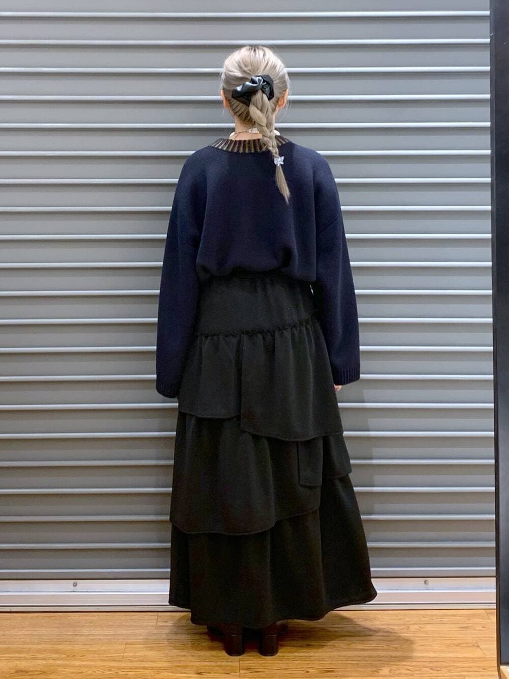 ブルー系のニット/セーター、グレー系のショルダーバッグ、ブラック系のブーツを着用したレディースの冬コーディネートの2枚目の写真