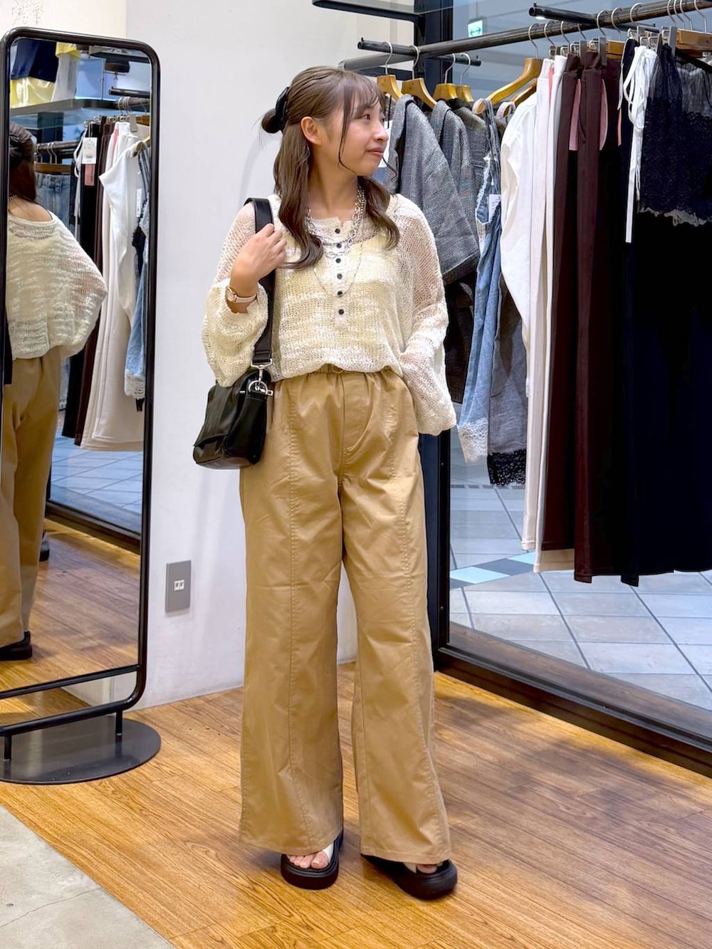 ベージュ系のその他パンツ、ホワイト系のニット/セーター、ブラック系のショルダーバッグを着用したレディースの秋コーディネートの4枚目の写真