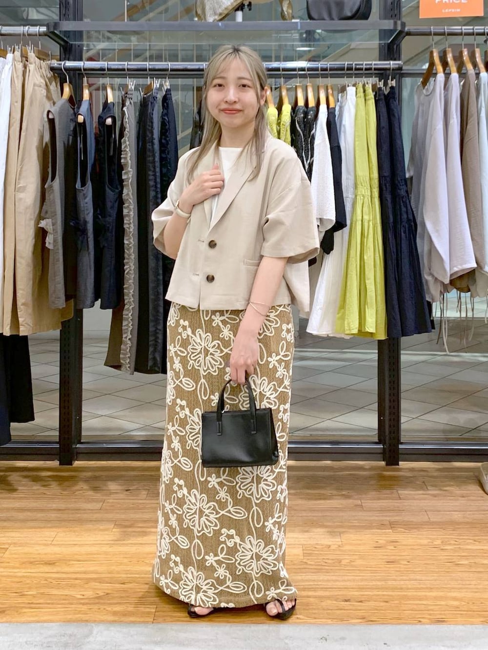 ホワイト系のTシャツ/カットソー、ブラック系のサンダル、ブラック系のショルダーバッグを着用したレディースの春コーディネートの7枚目の写真