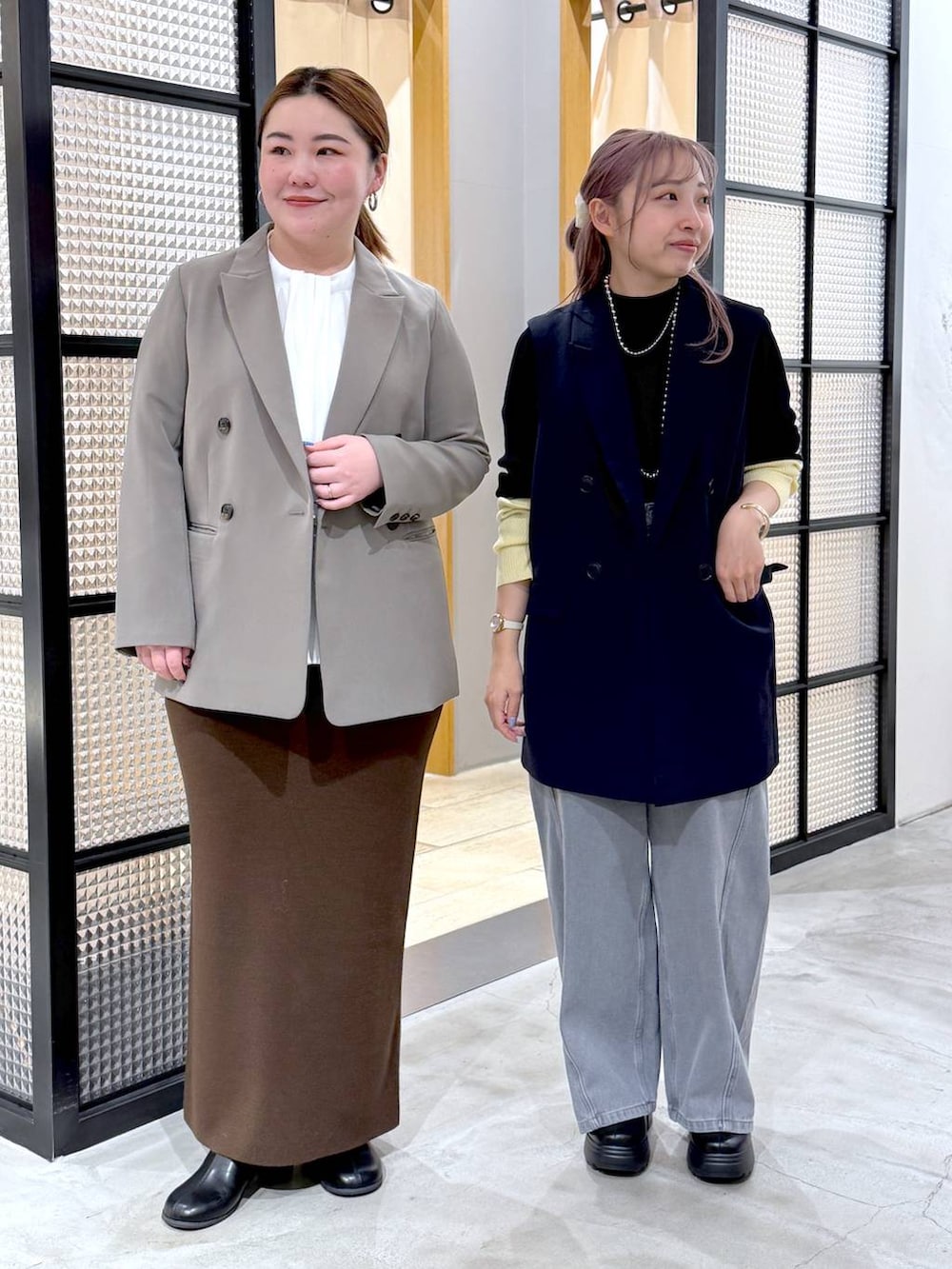 ブラウン系のスカート、ブラック系のニット/セーター、ブラック系のブーツを着用したレディースの冬コーディネートの4枚目の写真