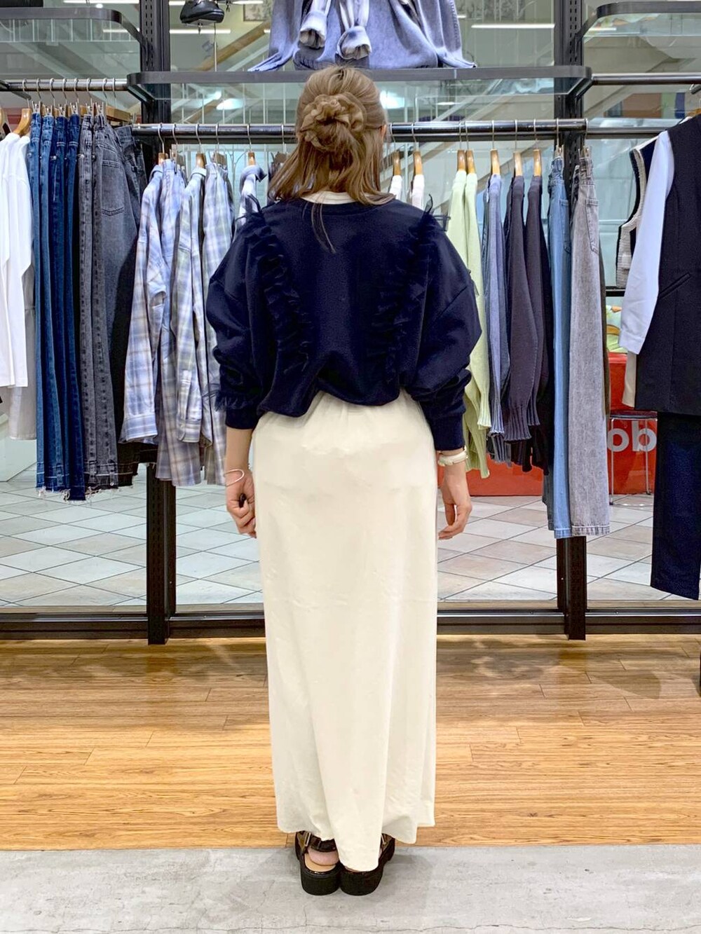 ブラック系のポンチョ、ホワイト系のスカート、ブラック系のショルダーバッグを着用したレディースの冬コーディネートの3枚目の写真