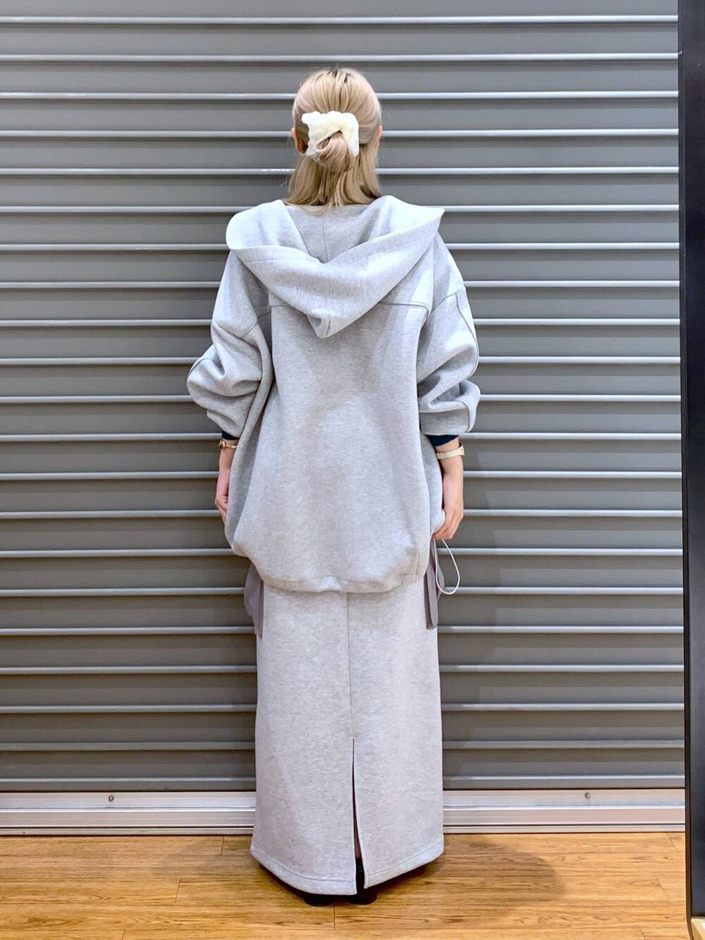 グレー系のブルゾン、ブラック系のニット/セーター、グレー系のスカートを着用したレディースの秋コーディネートの2枚目の写真