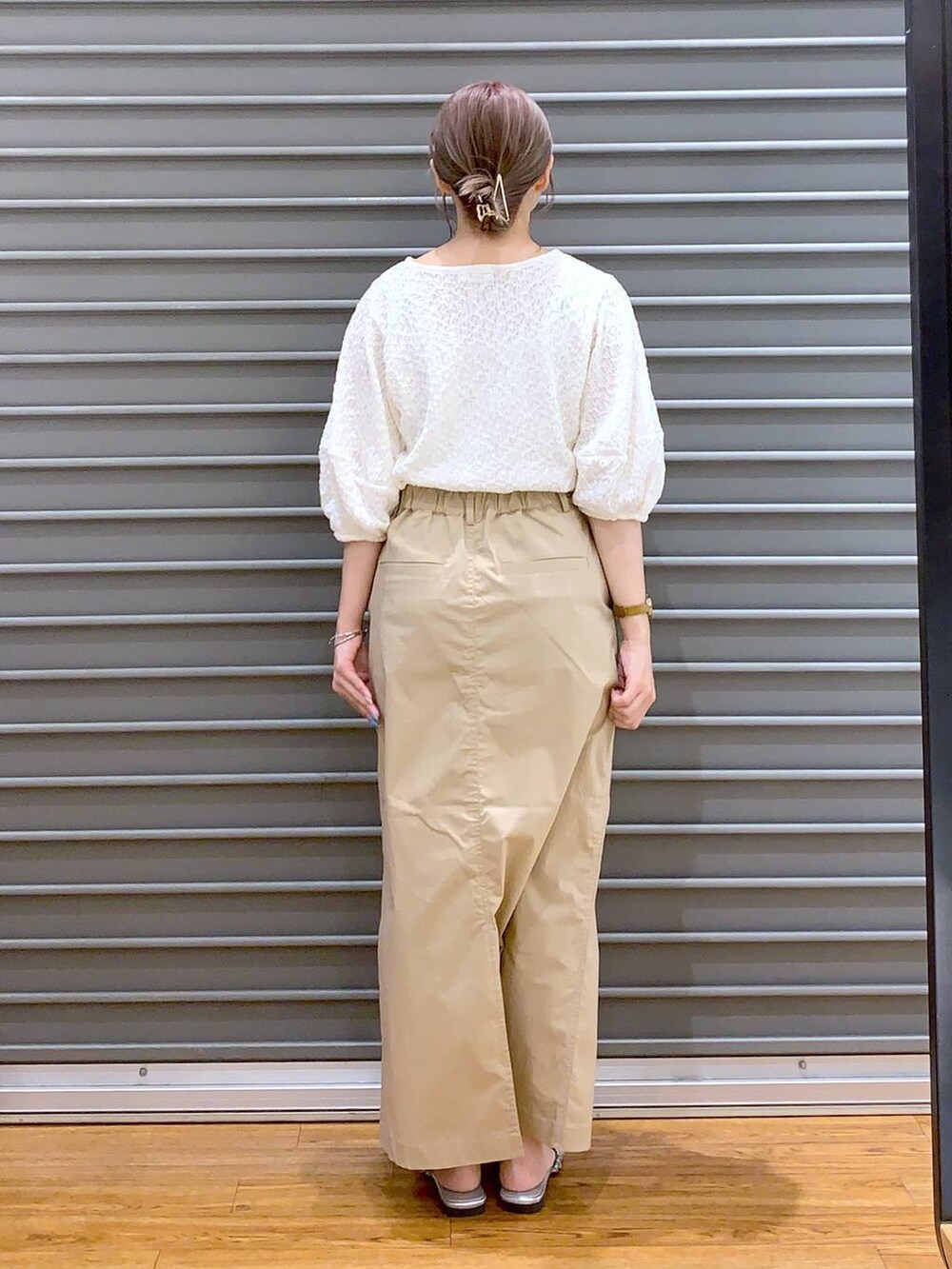 ホワイト系のTシャツ/カットソー、ベージュ系のスカート、ブラック系のショルダーバッグを着用したレディースの夏コーディネートの2枚目の写真