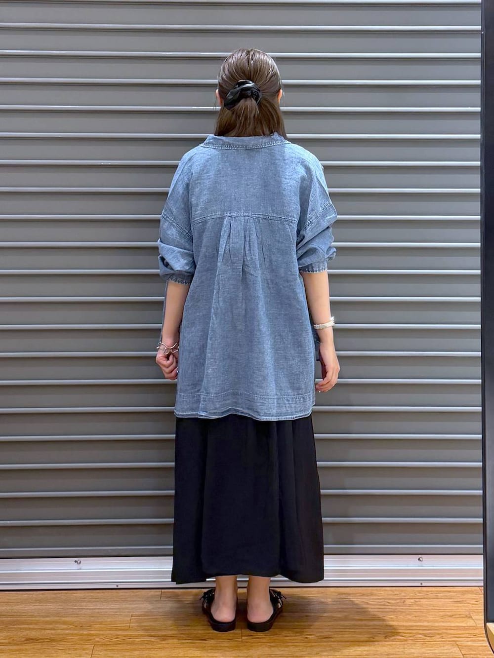 ブルー系のシャツ/ブラウス、ブラック系のサンダル、ブラック系のワンピースを着用したレディースの夏コーディネートの2枚目の写真