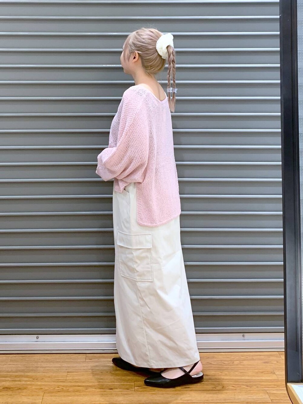 ピンク系のニット/セーター、ホワイト系のスカート、ブラック系のパンプスを着用したレディースの秋コーディネートの3枚目の写真