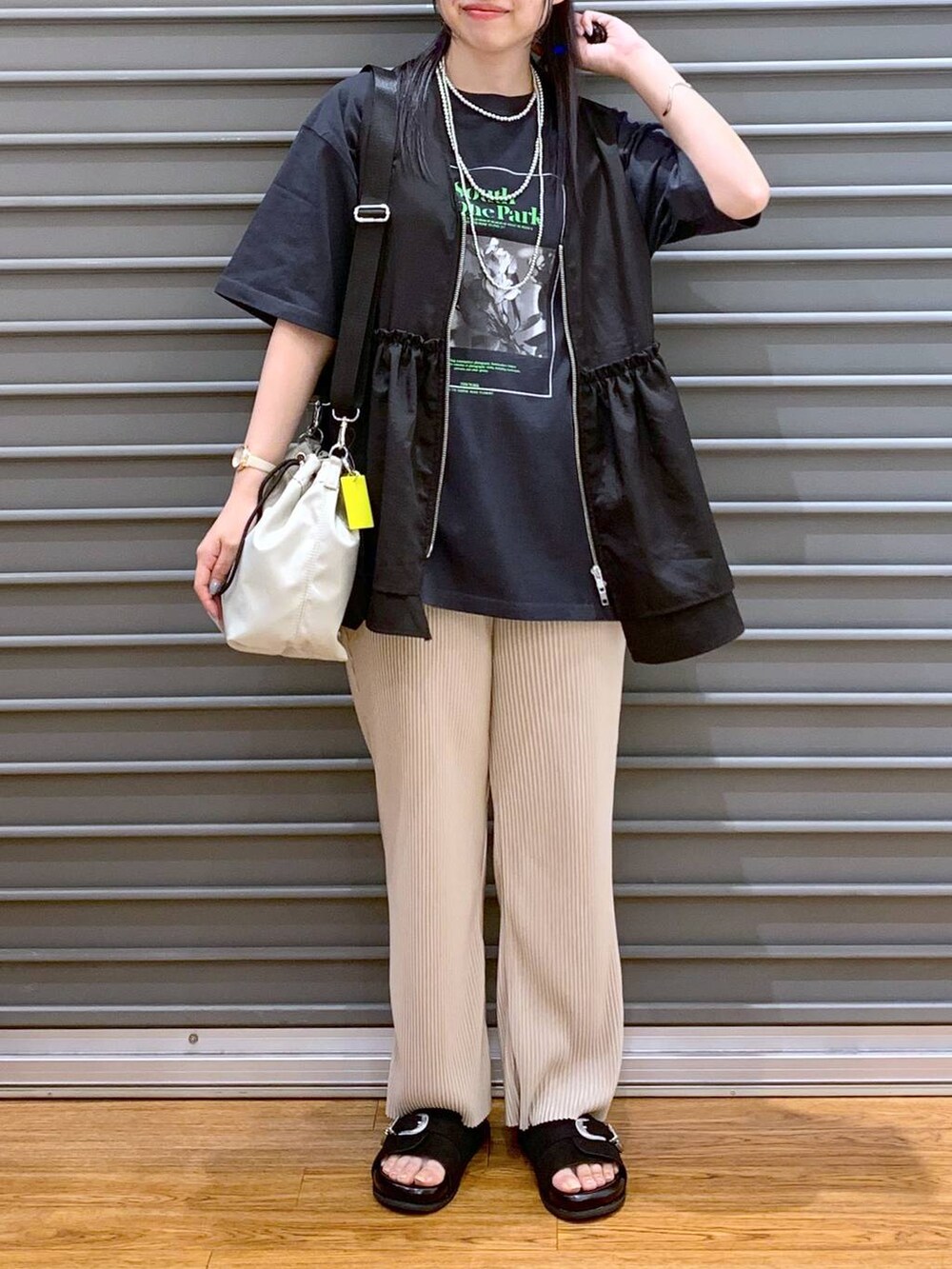 ブラック系のベスト、ベージュ系のその他パンツ、ブラック系のサンダルを着用したレディースの夏コーディネートの5枚目の写真