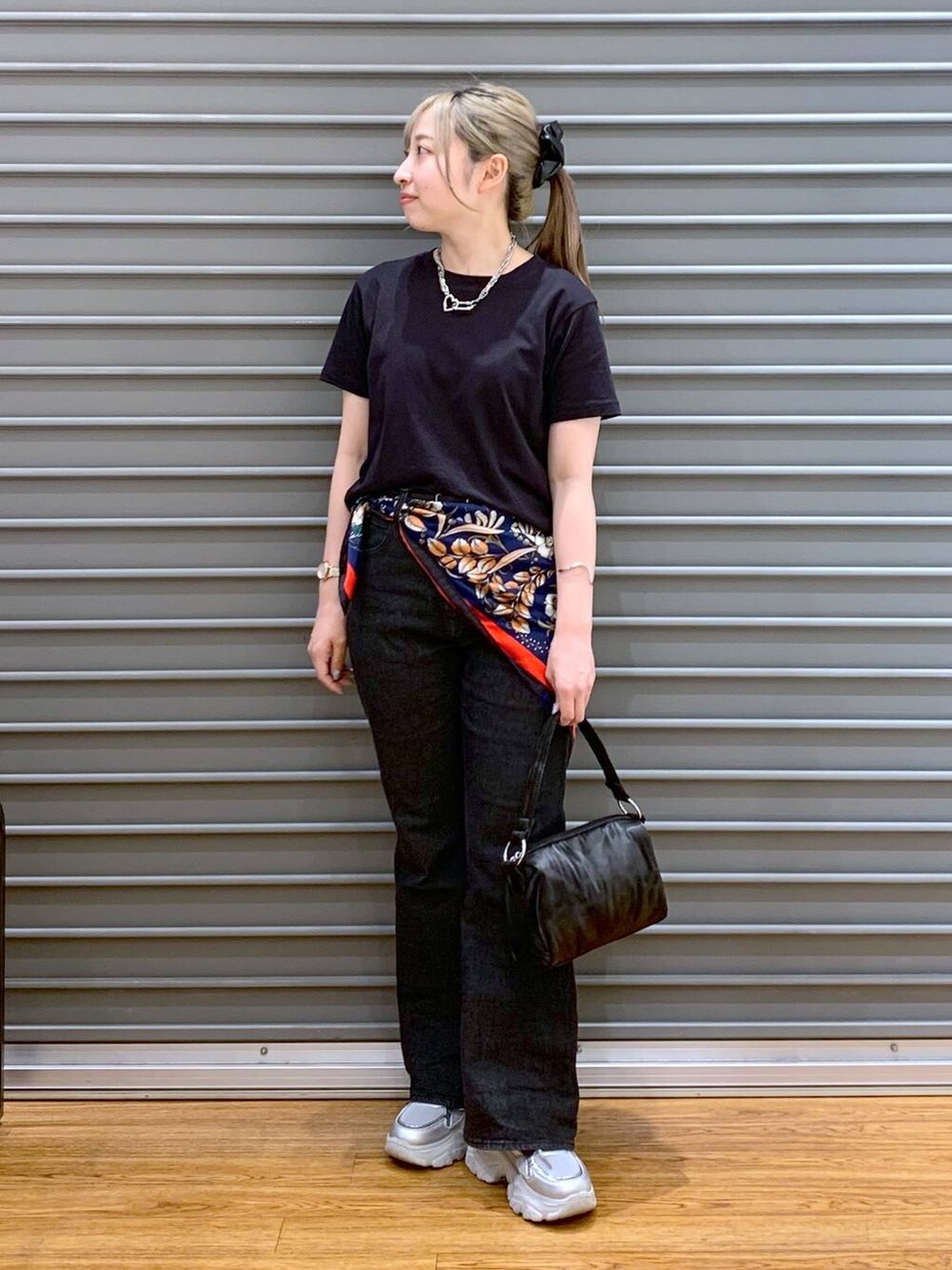 ブラック系のTシャツ/カットソー、ブラック系のデニムパンツ、シルバー系のスニーカーを着用したレディースの春コーディネートの4枚目の写真