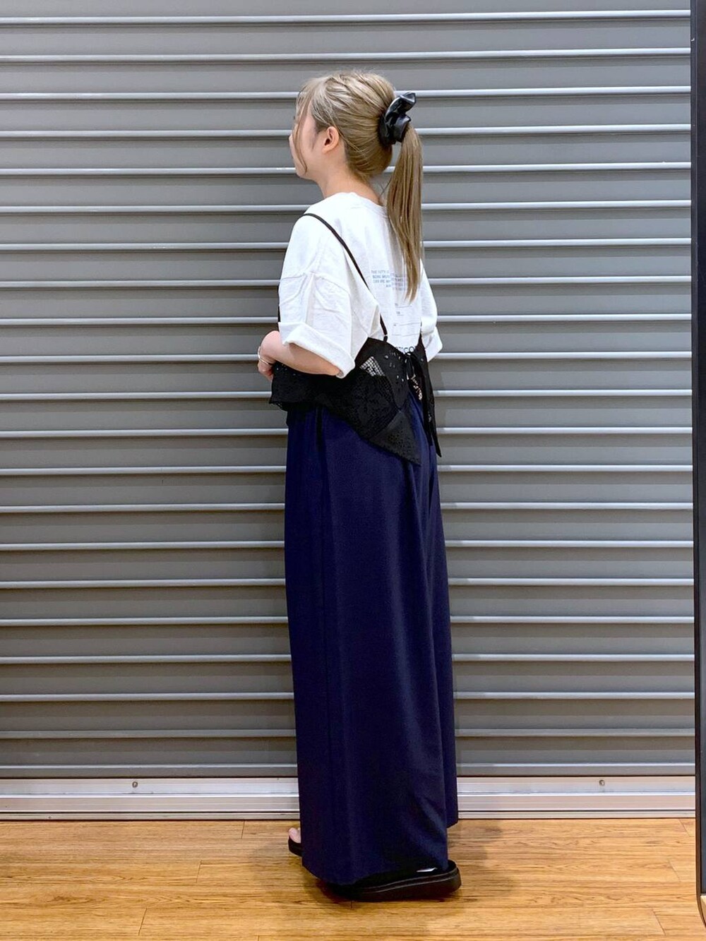 ブラック系のサンダル、ブルー系のその他パンツ、ホワイト系のショルダーバッグを着用したレディースの夏コーディネートの3枚目の写真