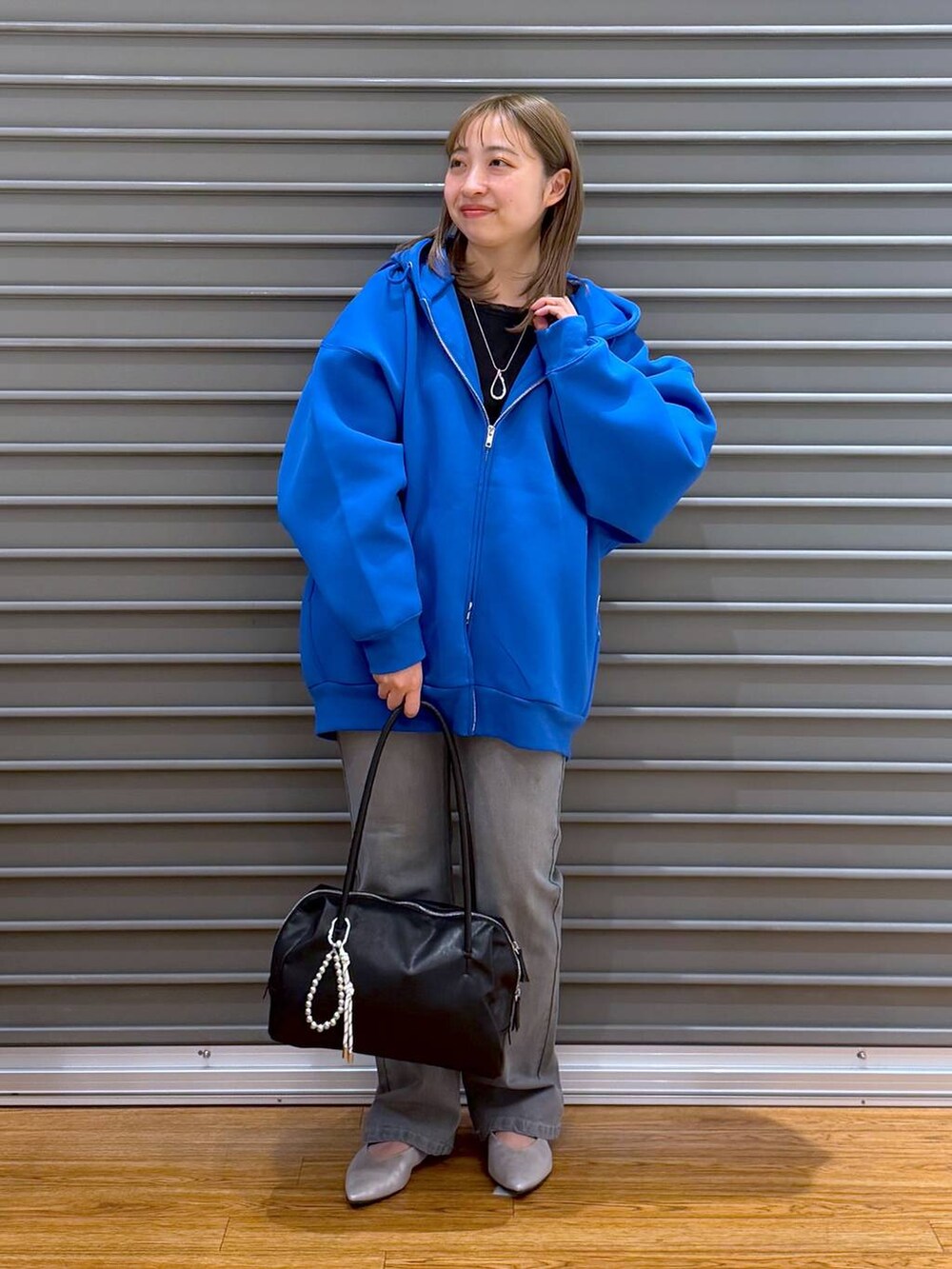 ブルー系のパーカー、ブラック系のTシャツ/カットソー、シルバー系のパンプスを着用したレディースの春コーディネートの5枚目の写真