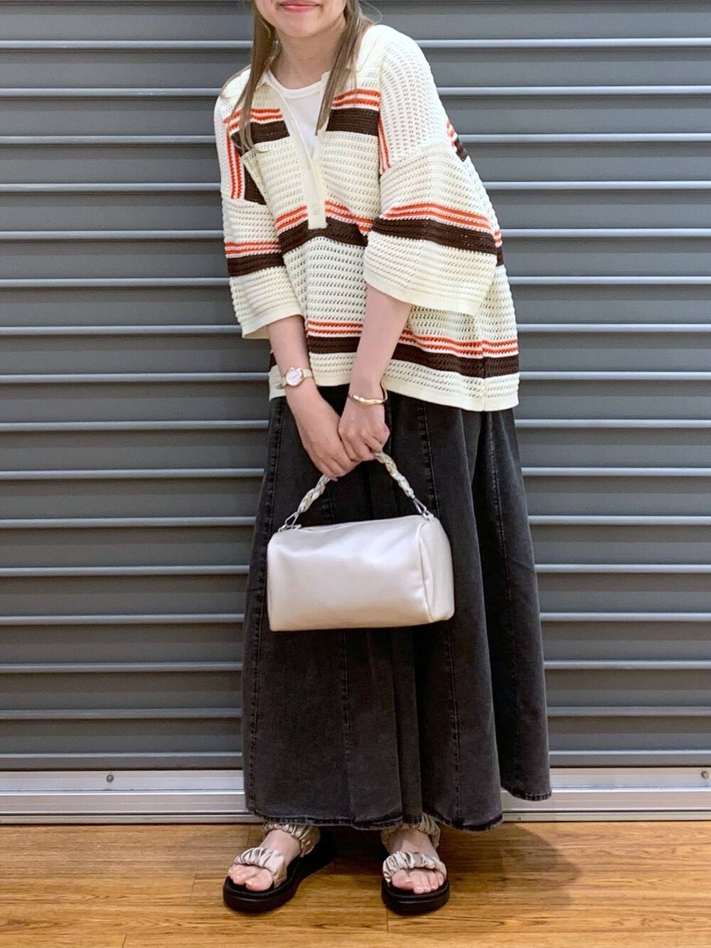 ベージュ系のサンダル、グレー系のスカート、ホワイト系のショルダーバッグを着用したレディースの春コーディネートの7枚目の写真