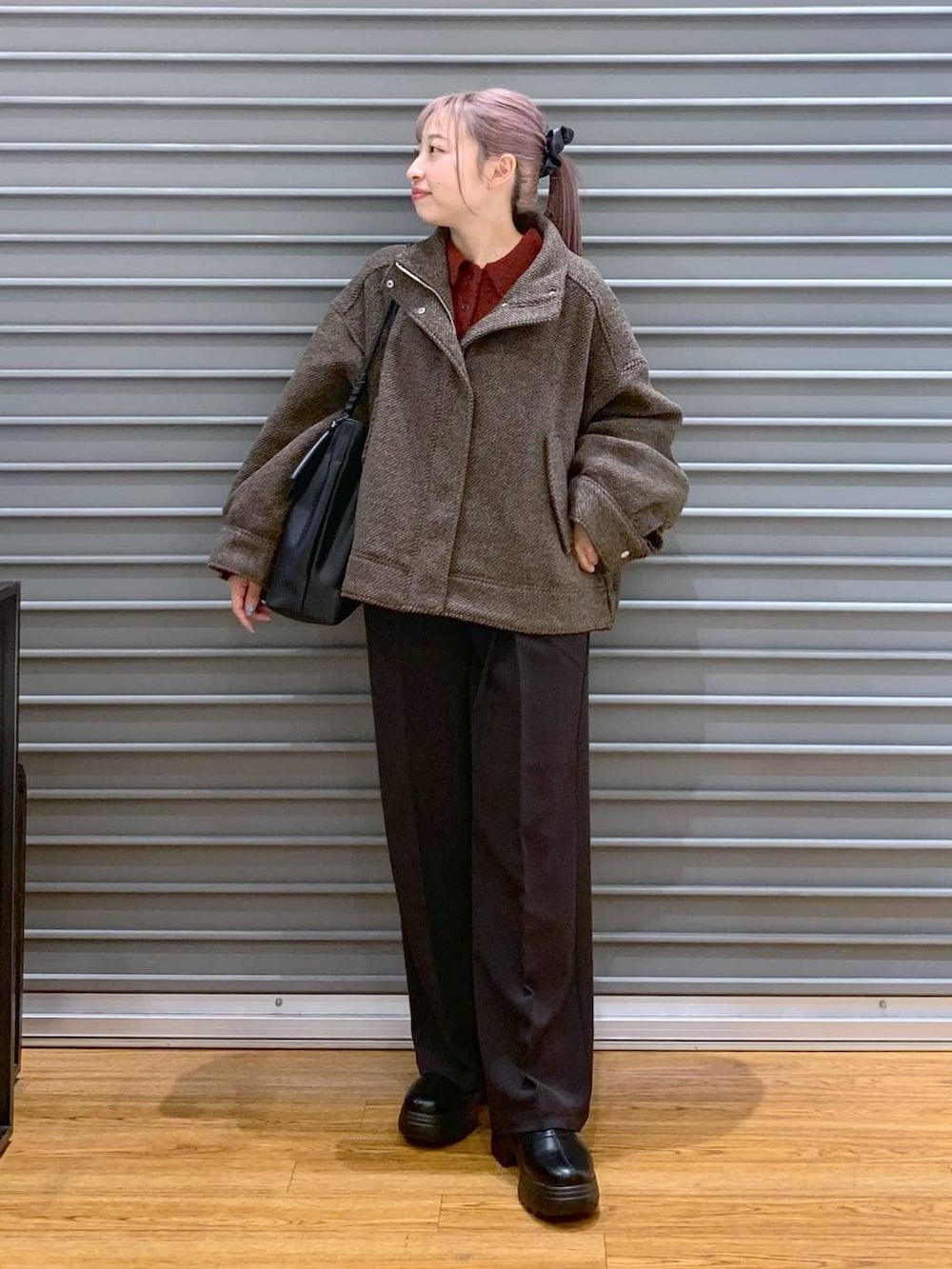 ブラウン系のブルゾン、ブラック系のブーツ、ブラック系のその他パンツを着用したレディースの冬コーディネートの4枚目の写真