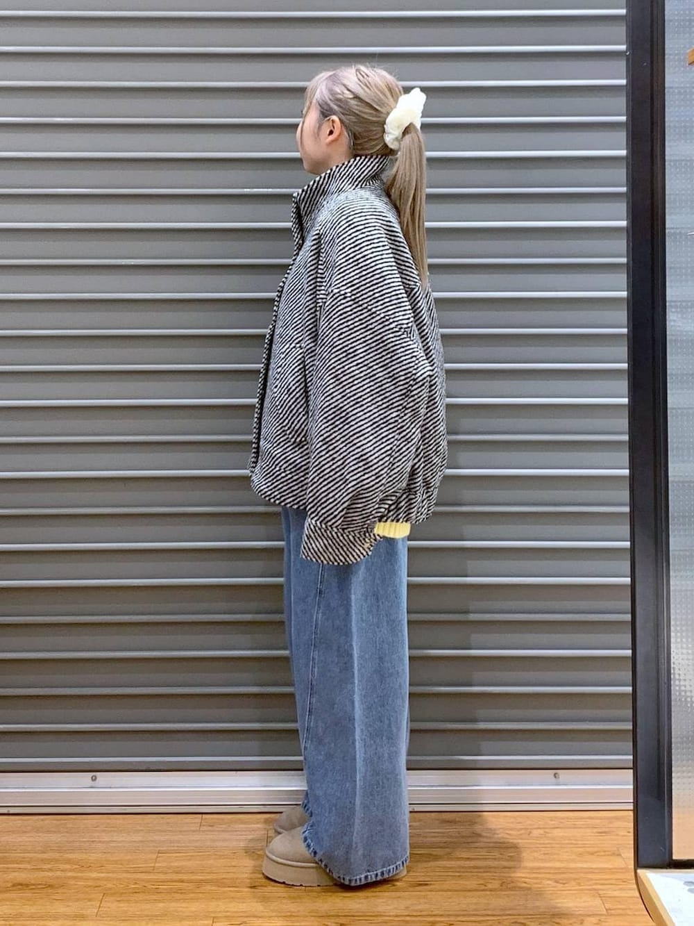 イエロー系のニット/セーター、ブラック系のブルゾン、ブラック系のトートバッグを着用したレディースの冬コーディネートの4枚目の写真