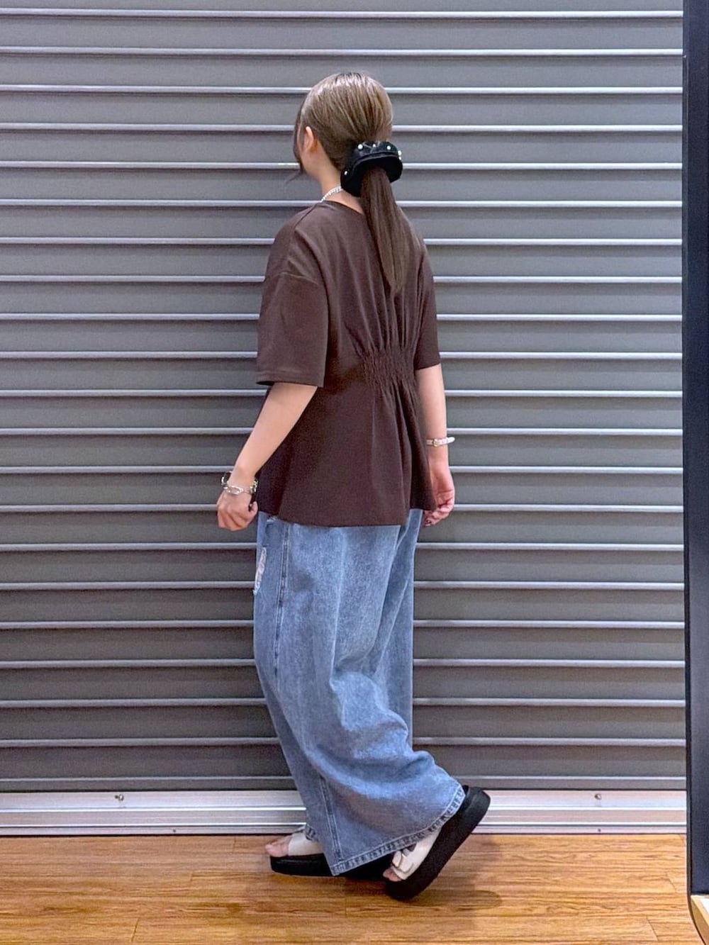 ホワイト系のサンダル、ホワイト系のトートバッグ、ブラウン系のTシャツ/カットソーを着用したレディースの夏コーディネートの3枚目の写真