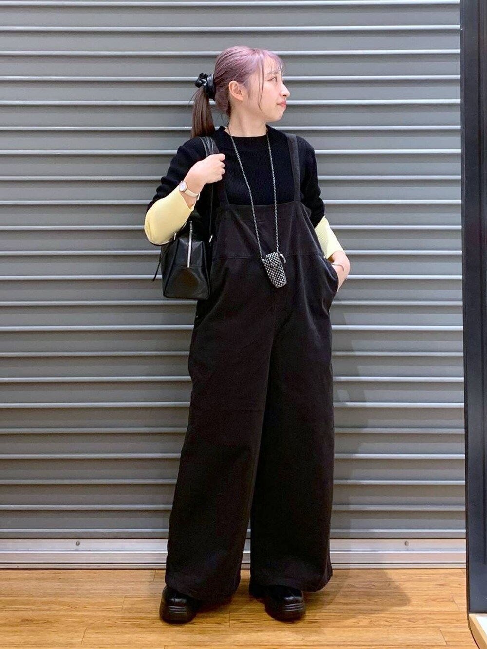 ブラック系のニット/セーター、ブラック系のボストンバッグ、ブラック系のブーツを着用したレディースの冬コーディネートの4枚目の写真