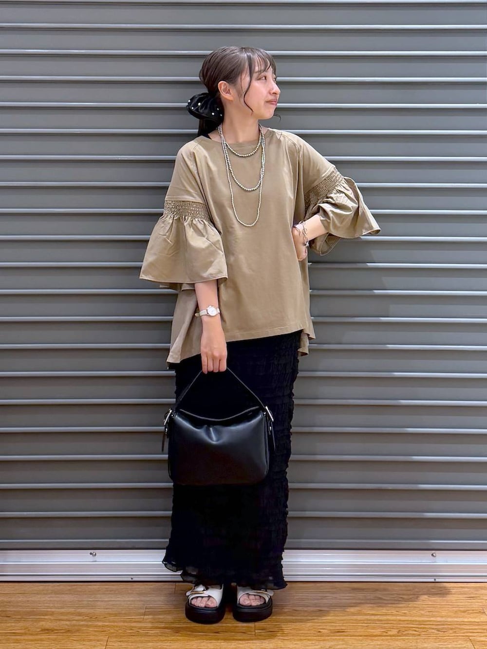 ベージュ系のTシャツ/カットソー、ホワイト系のサンダル、ブラック系のショルダーバッグを着用したレディースの夏コーディネートの4枚目の写真