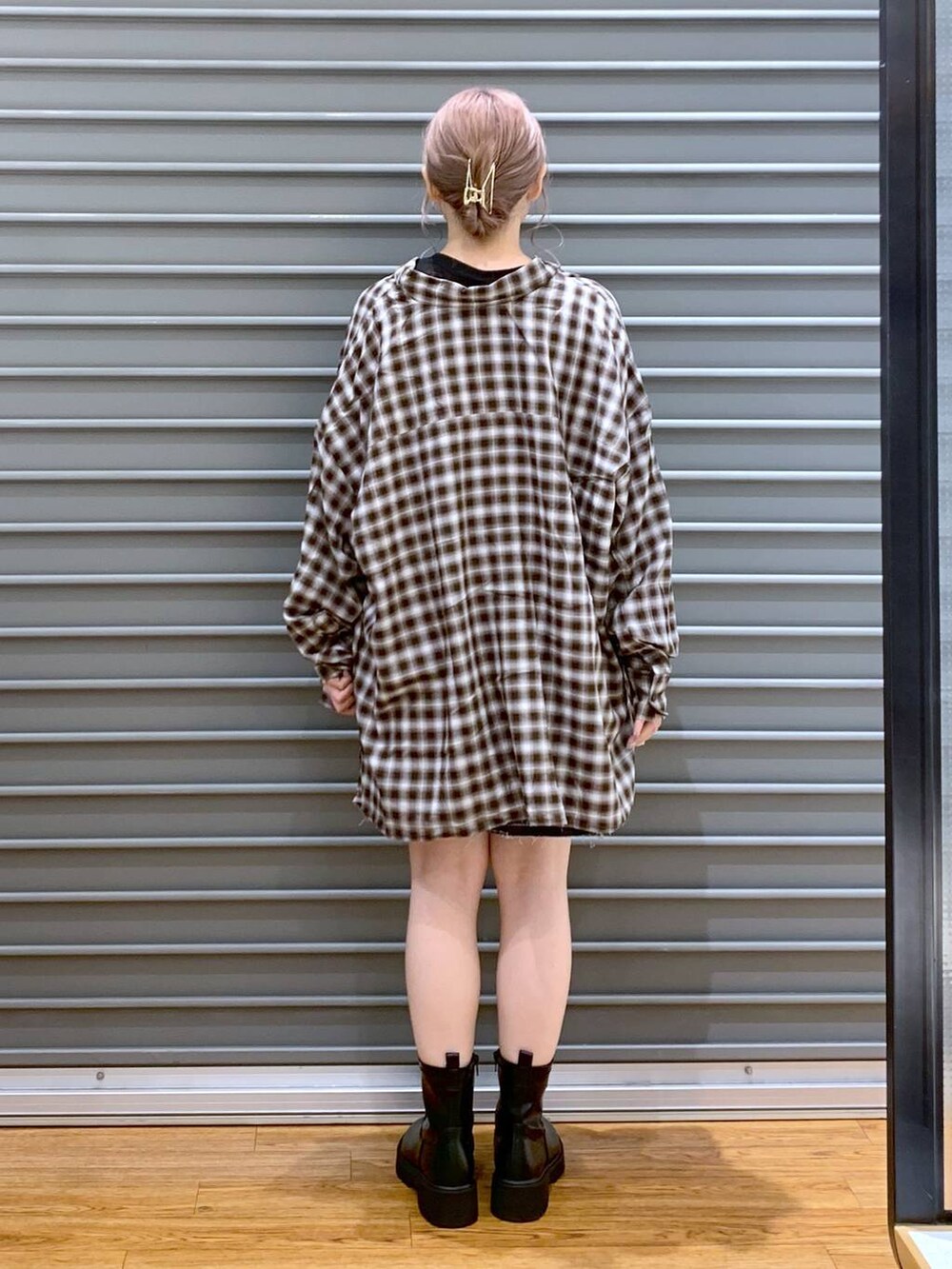 ブラック系のTシャツ/カットソー、ブラック系のボストンバッグ、ブラック系のブーツを着用したレディースの秋コーディネートの2枚目の写真