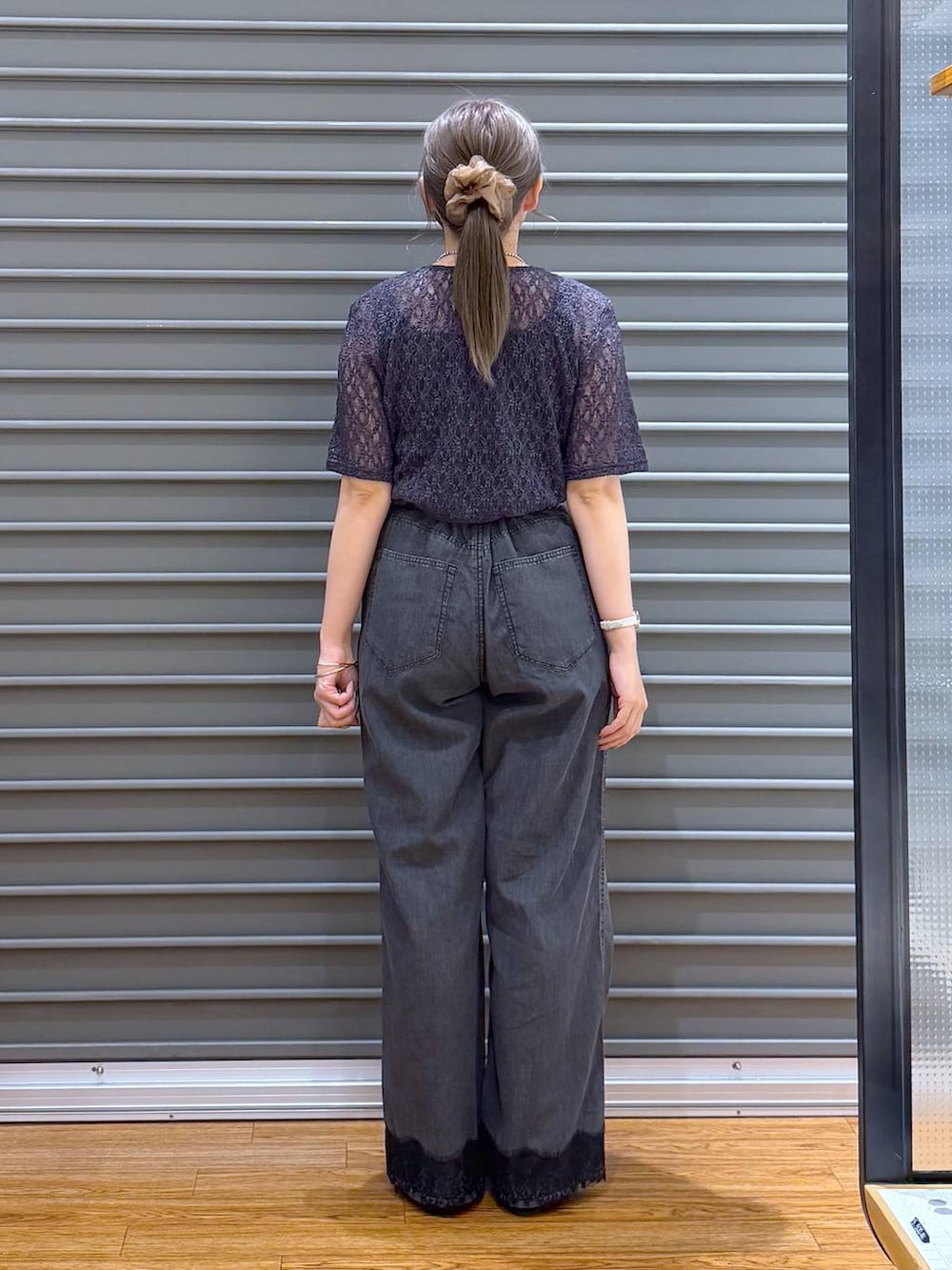 ブラック系のショルダーバッグ、ブラック系のパンプス、グレー系のTシャツ/カットソーを着用したレディースの夏コーディネートの2枚目の写真