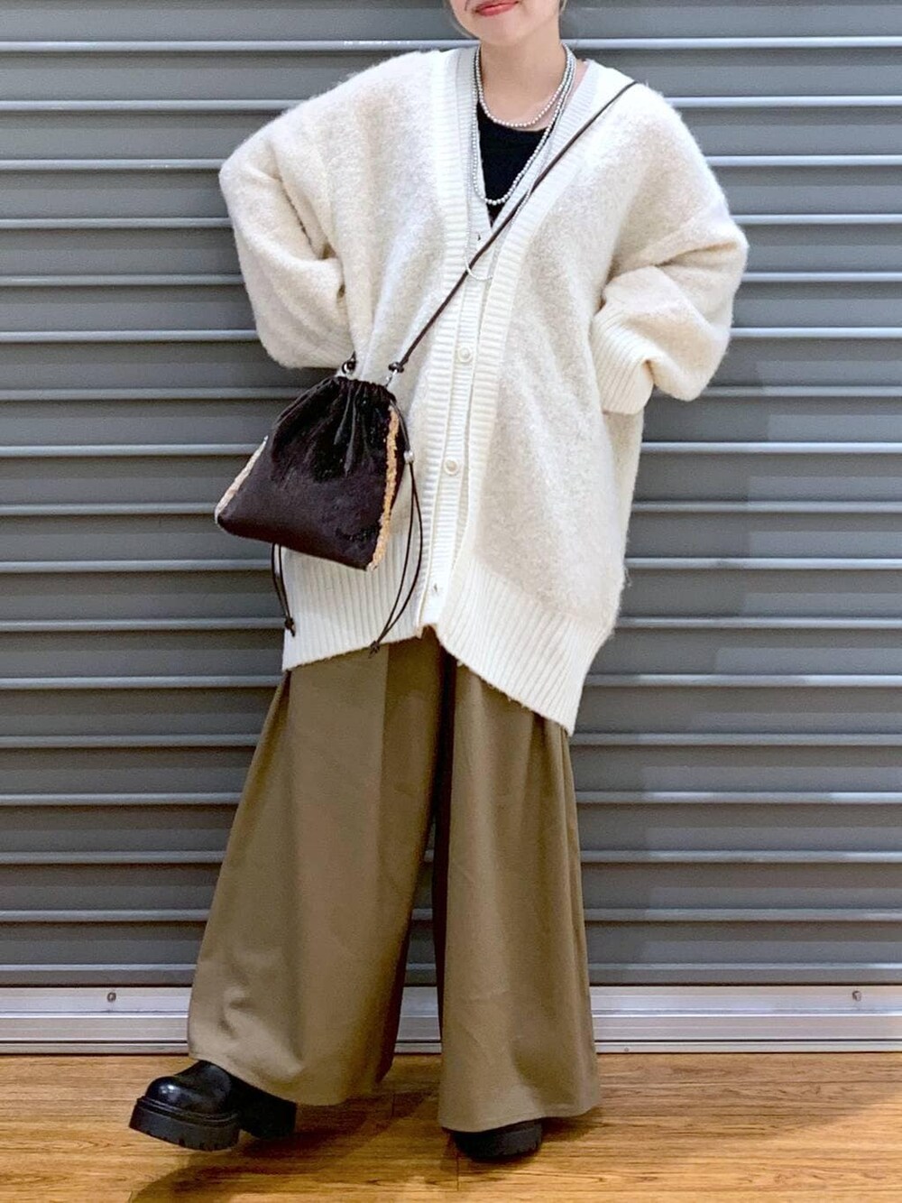 ブラウン系のその他パンツ、ホワイト系のカーディガン/ボレロ、ブラウン系のショルダーバッグを着用したレディースの秋コーディネートの5枚目の写真