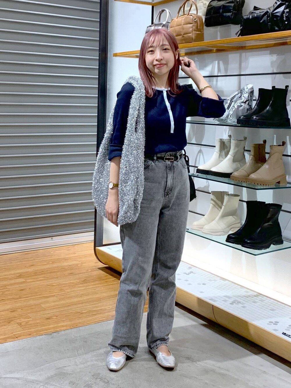 シルバー系のショルダーバッグ、シルバー系のパンプス、グレー系のデニムパンツを着用したレディースの秋コーディネートの7枚目の写真