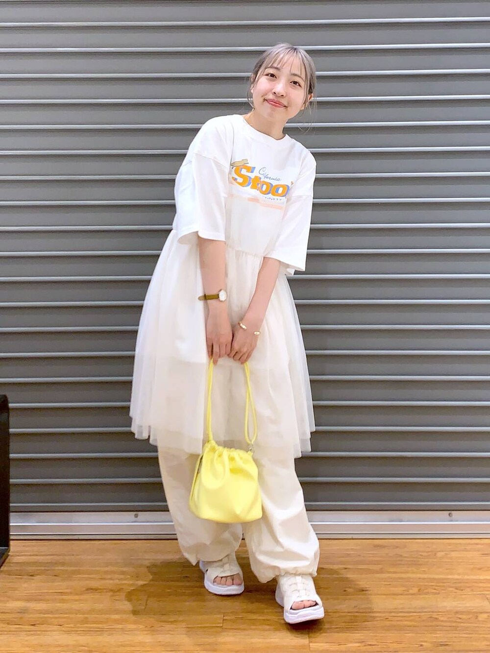 ホワイト系のサンダル、イエロー系のショルダーバッグ、ホワイト系のカーゴパンツを着用したレディースの春コーディネートの4枚目の写真