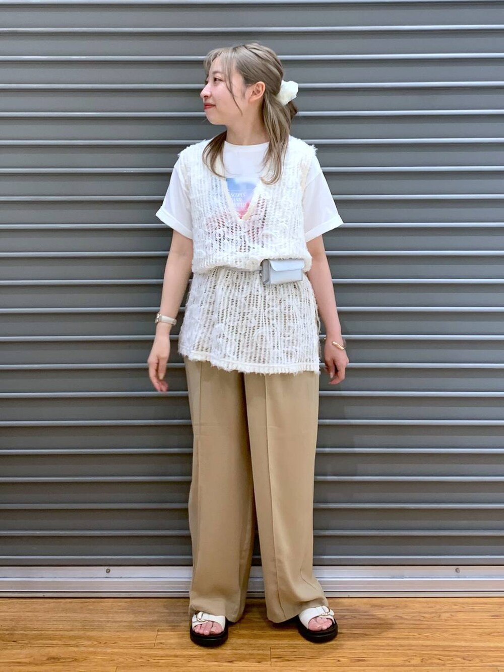 ベージュ系のその他パンツ、ホワイト系のベスト、ホワイト系のサンダルを着用したレディースの春コーディネートの5枚目の写真