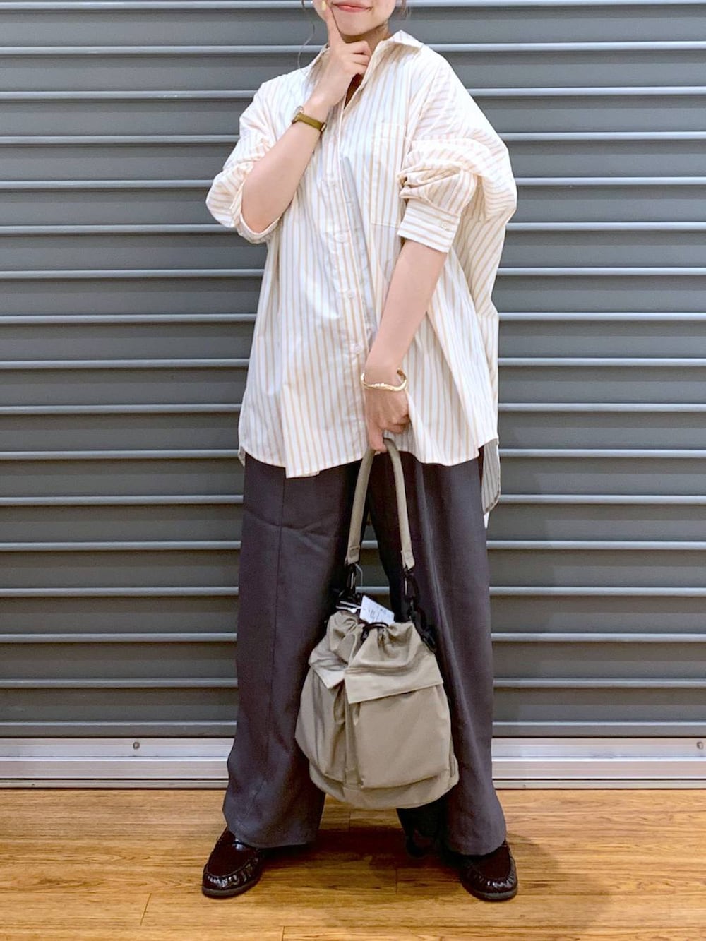 ベージュ系のショルダーバッグ、ブラウン系のローファー、グレー系のその他パンツを着用したレディースの秋コーディネートの5枚目の写真
