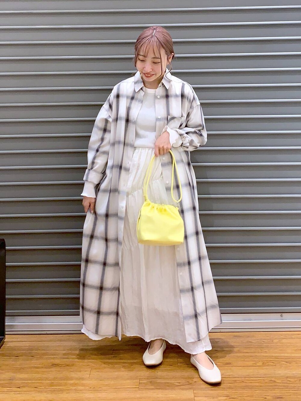 イエロー系のショルダーバッグ、ホワイト系のパンプス、ホワイト系のTシャツ/カットソーを着用したレディースの春コーディネートの3枚目の写真