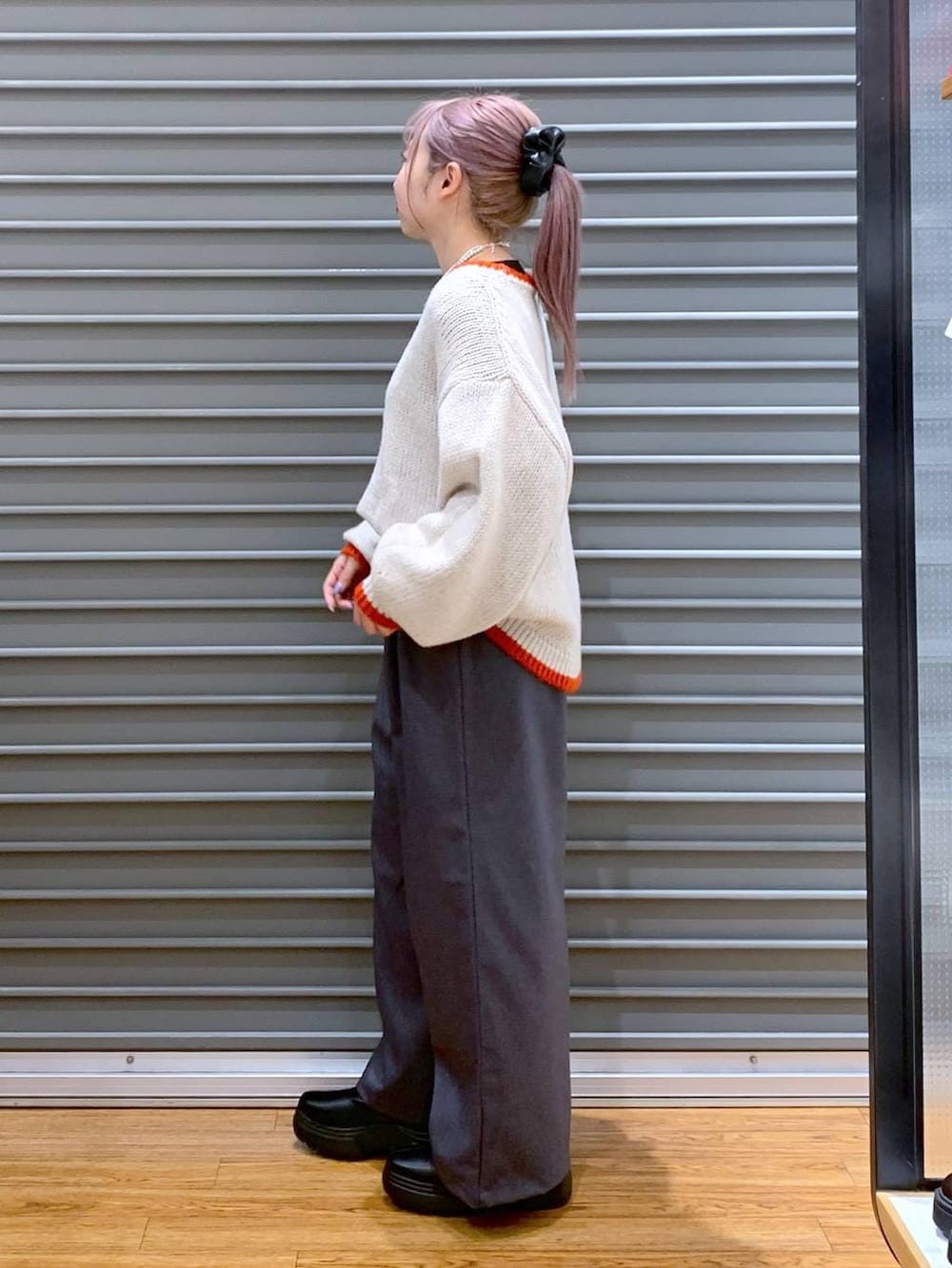 ブラック系のその他アウター、ブラック系のブーツ、ブラック系のショルダーバッグを着用したレディースの冬コーディネートの5枚目の写真