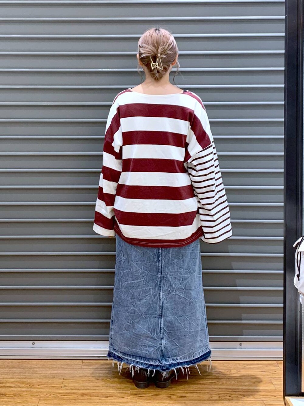 レッド系のTシャツ/カットソー、ブルー系のデニムスカート、ブラウン系のローファーを着用したレディースの秋コーディネートの2枚目の写真