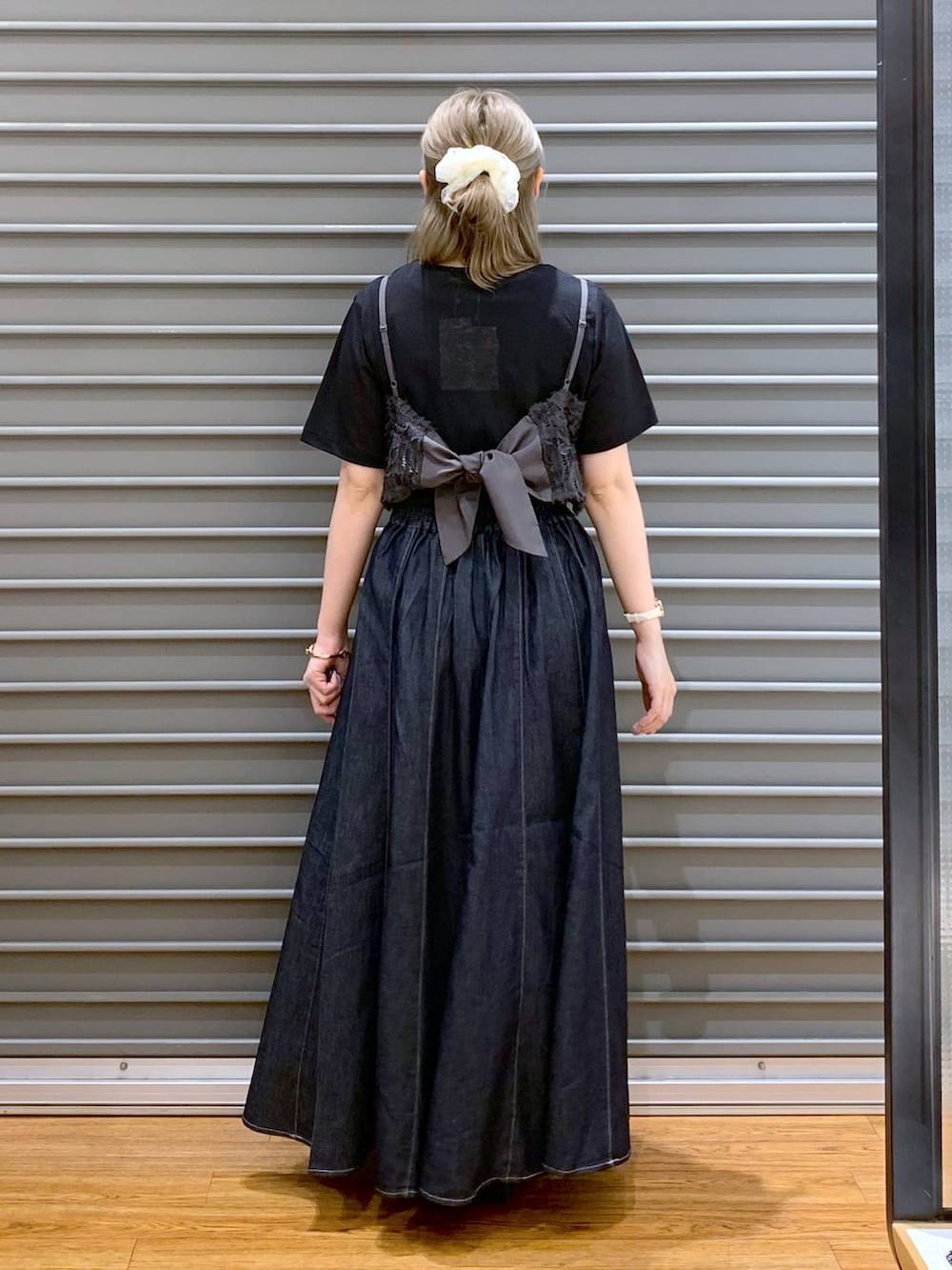 ブルー系のスカート、ホワイト系のサンダル、ブラック系のショルダーバッグを着用したレディースの夏コーディネートの2枚目の写真