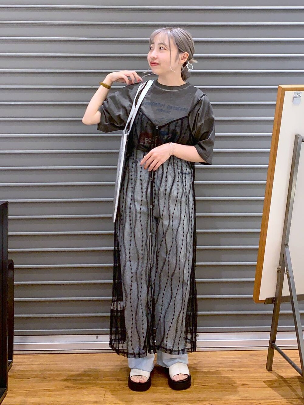 グレー系のTシャツ/カットソー、ブルー系のデニムパンツ、ホワイト系のサンダルを着用したレディースの夏コーディネートの4枚目の写真