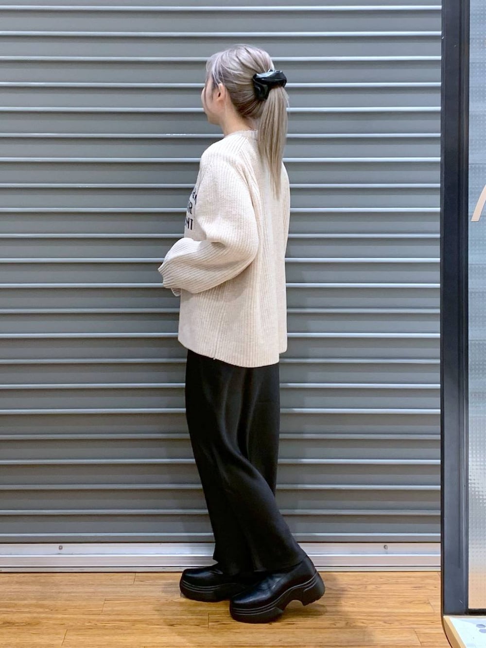 ブラック系のスカート、グリーン系のショルダーバッグ、ブラック系のブルゾンを着用したレディースの冬コーディネートの5枚目の写真