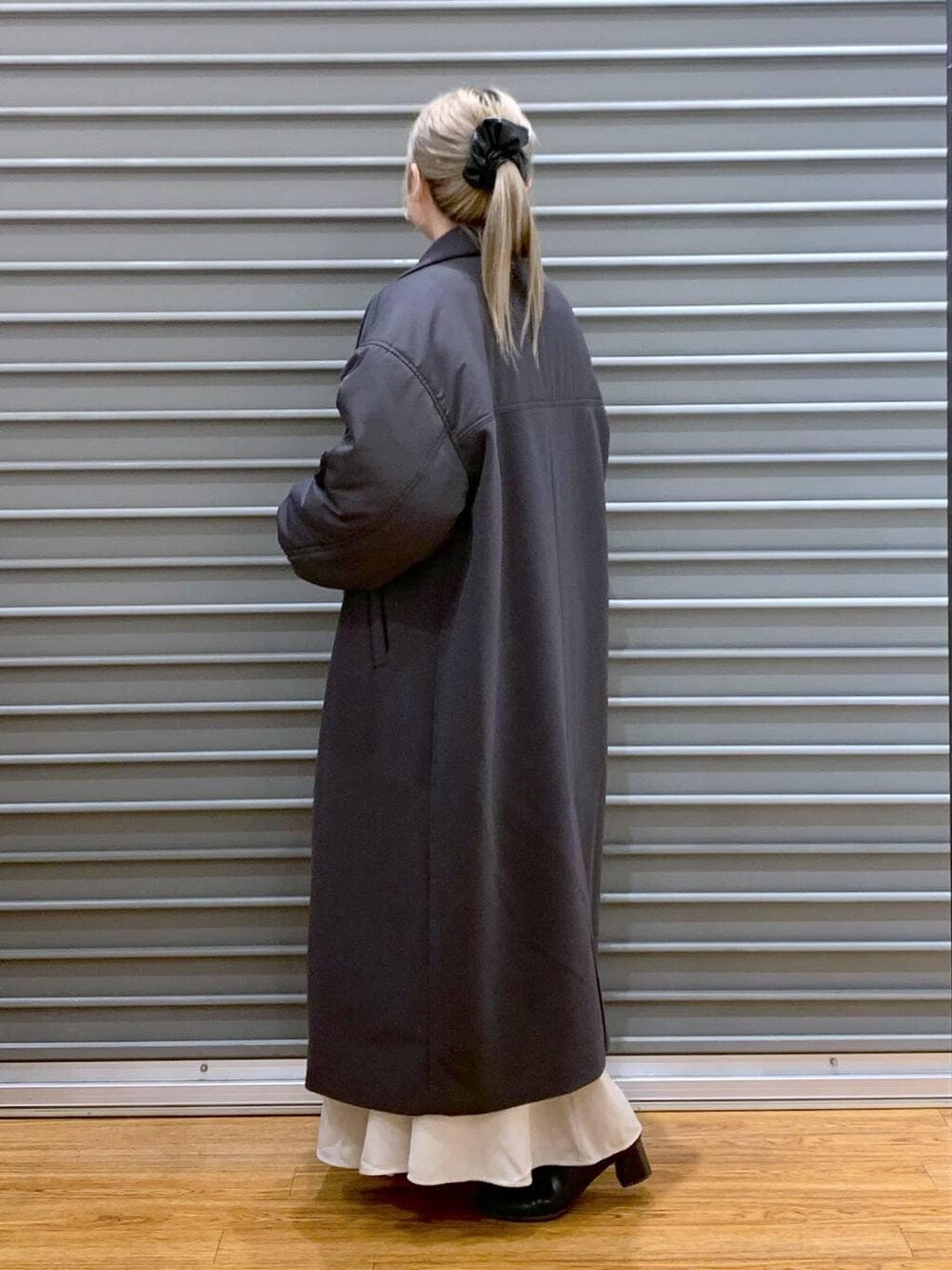 ブラック系のショルダーバッグ、ホワイト系のニット/セーター、ブラック系のブーツを着用したレディースの冬コーディネートの4枚目の写真