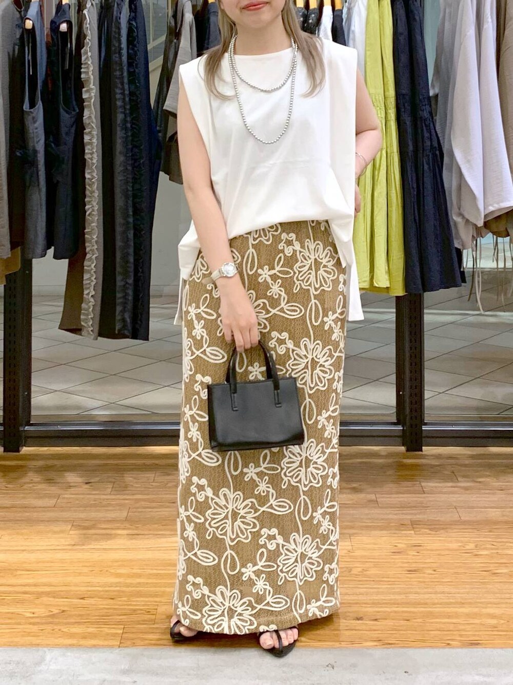 ホワイト系のTシャツ/カットソー、ブラック系のサンダル、ブラック系のショルダーバッグを着用したレディースの夏コーディネートの5枚目の写真