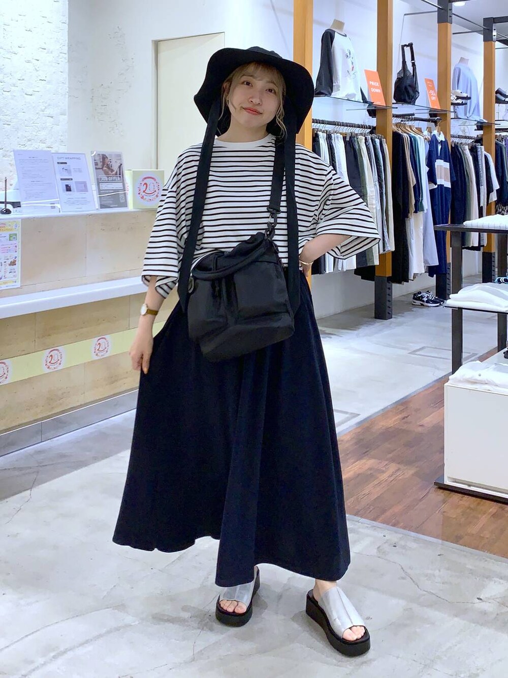 ブラック系のショルダーバッグ、グレー系のサンダル、グレー系のTシャツ/カットソーを着用したレディースの春コーディネートの3枚目の写真