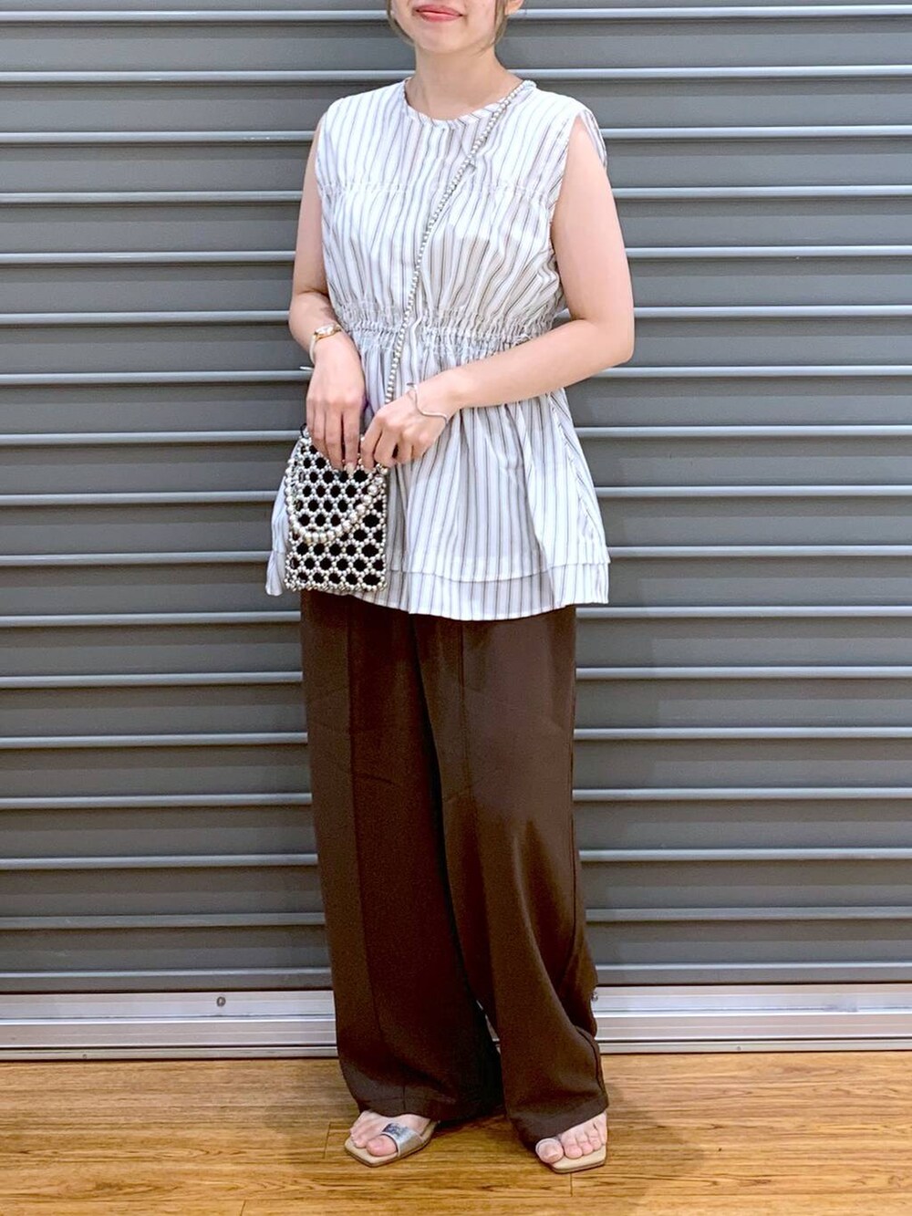 ブラウン系のその他パンツ、シルバー系のショルダーバッグ、ベージュ系のサンダルを着用したレディースの夏コーディネートの6枚目の写真