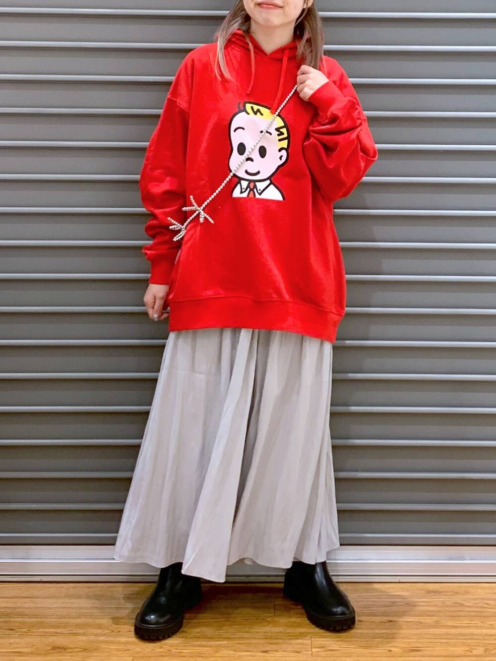 グレー系のその他パンツ、ブラック系のブーツ、レッド系のパーカーを着用したレディースの冬コーディネートの5枚目の写真