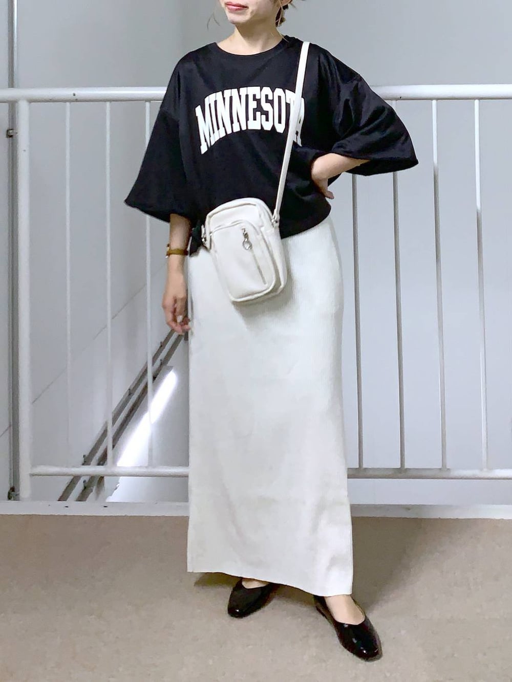 ブラック系のTシャツ/カットソー、ホワイト系のスカート、ホワイト系のショルダーバッグを着用したレディースの夏コーディネートの4枚目の写真