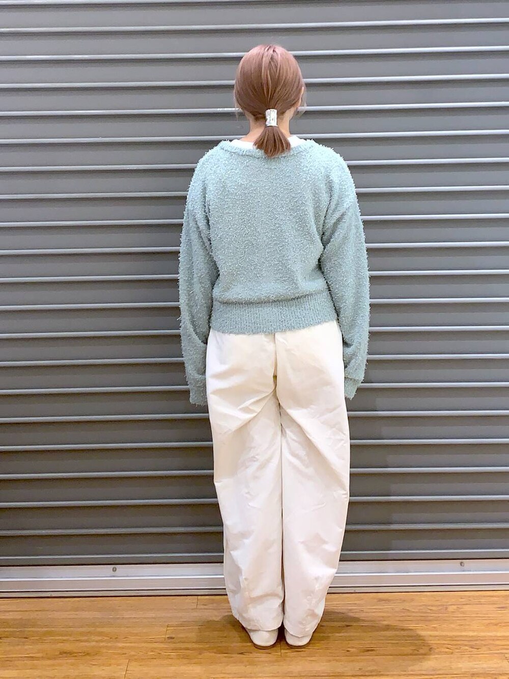 ホワイト系のショルダーバッグ、ホワイト系のパンプス、グリーン系のカーディガン/ボレロを着用したレディースの春コーディネートの2枚目の写真