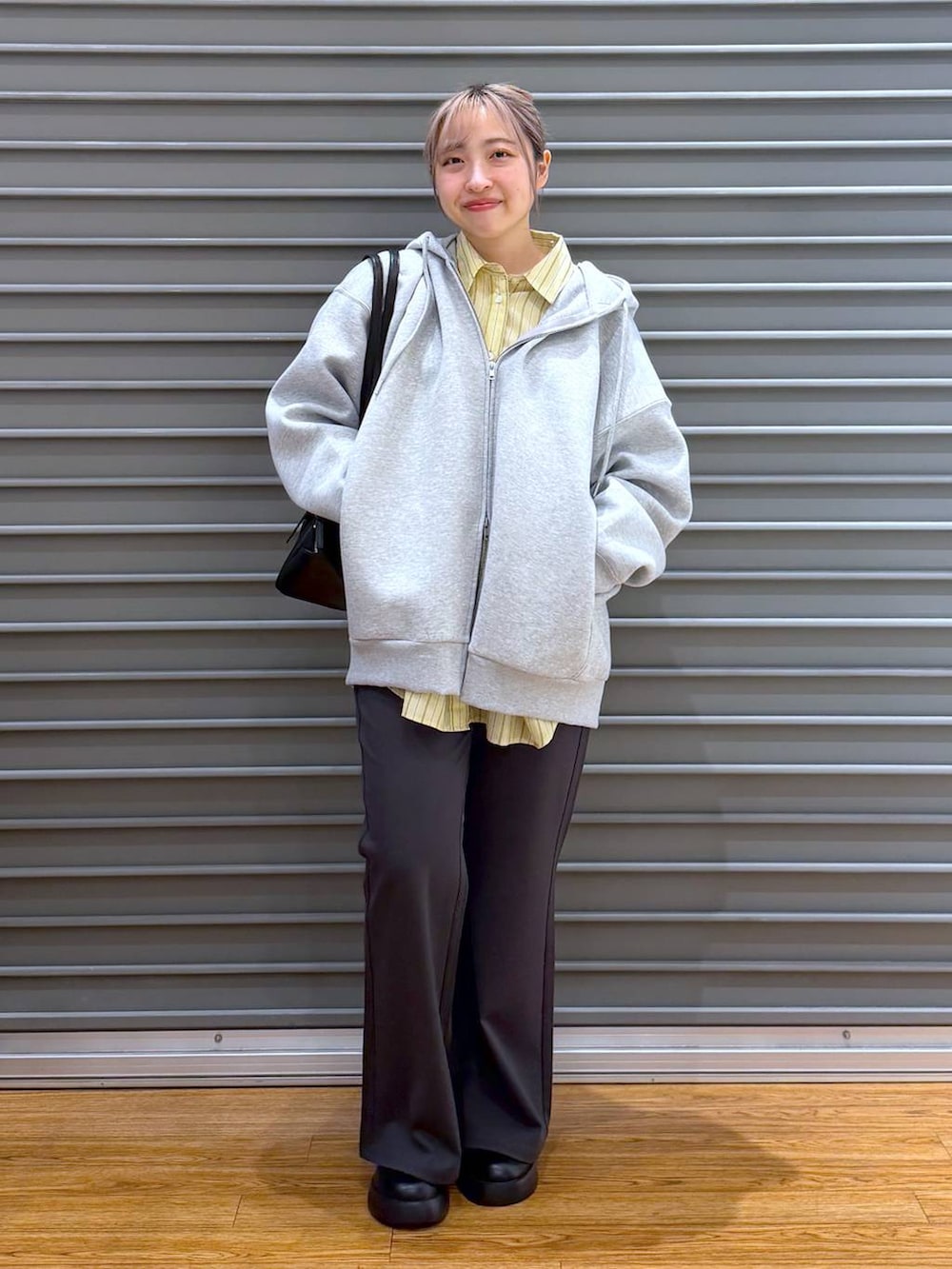 ブラック系のサンダル、ブラック系のボストンバッグ、グレー系のパーカーを着用したレディースの冬コーディネートの7枚目の写真