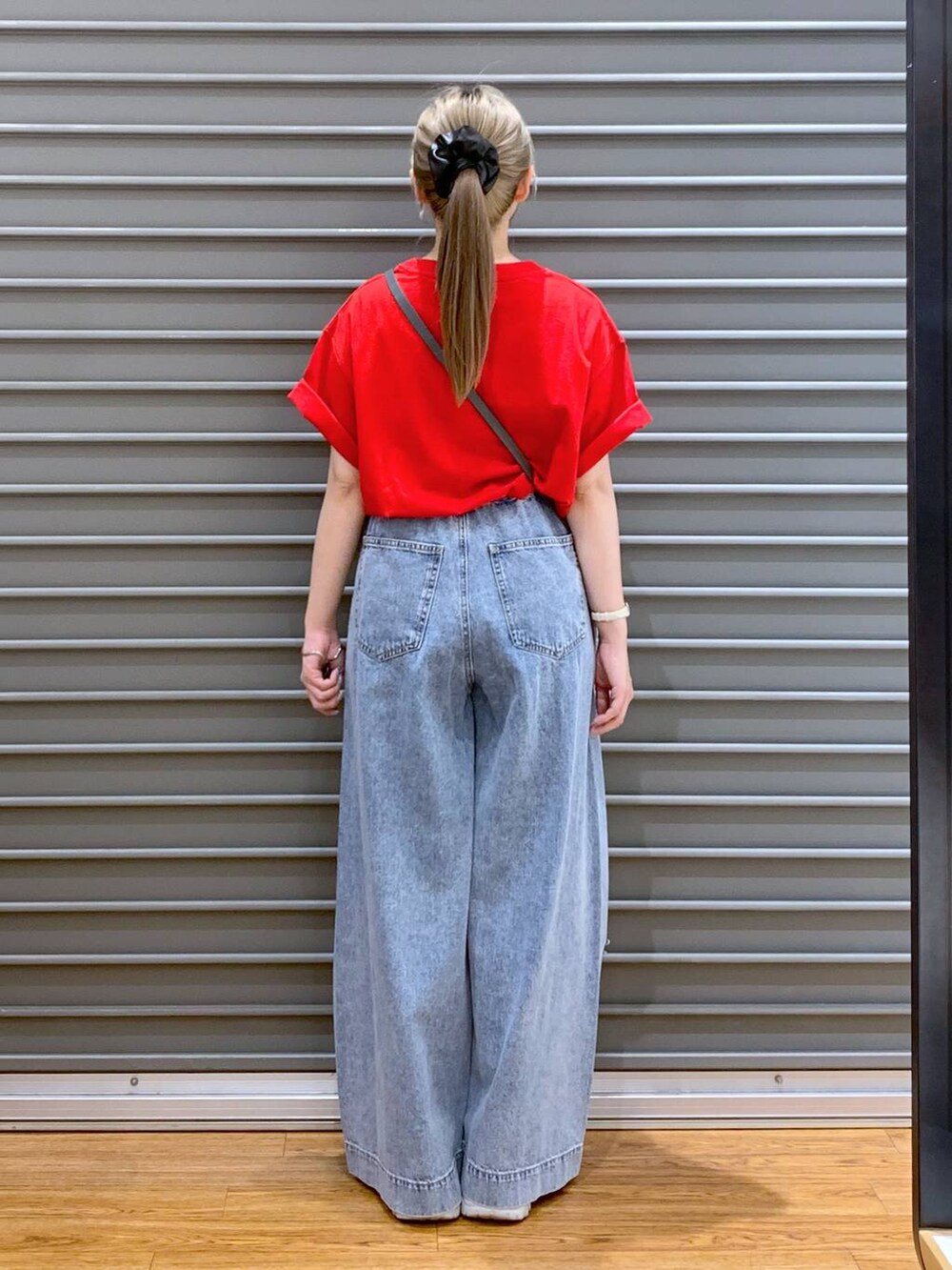 ブルー系のデニムパンツ、シルバー系のスニーカー、レッド系のTシャツ/カットソーを着用したレディースの夏コーディネートの2枚目の写真