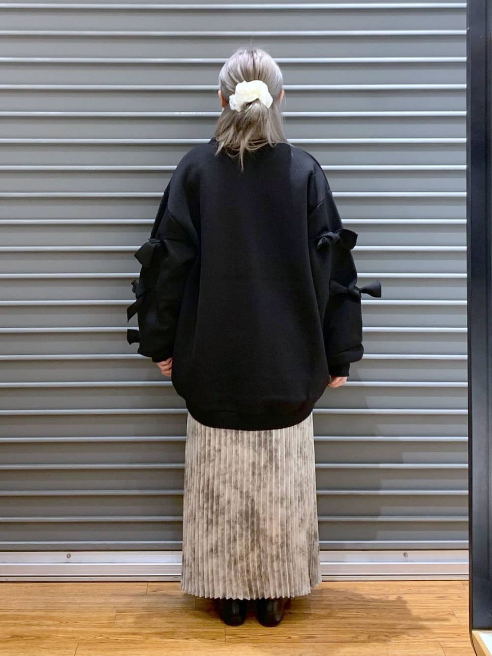 ホワイト系のスカート、ブラック系のボストンバッグ、ブラック系のスウェットを着用したレディースの秋コーディネートの2枚目の写真