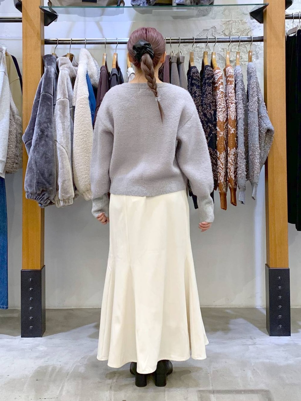 ブラック系のボストンバッグ、ブラック系のブーツ、ホワイト系のブルゾンを着用したレディースの冬コーディネートの3枚目の写真