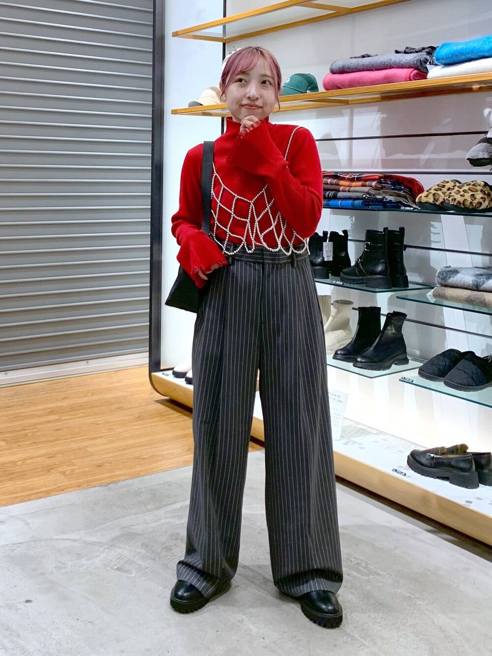 ホワイト系のベスト、ブラック系のブーツ、ブラック系のショルダーバッグを着用したレディースの冬コーディネートの5枚目の写真