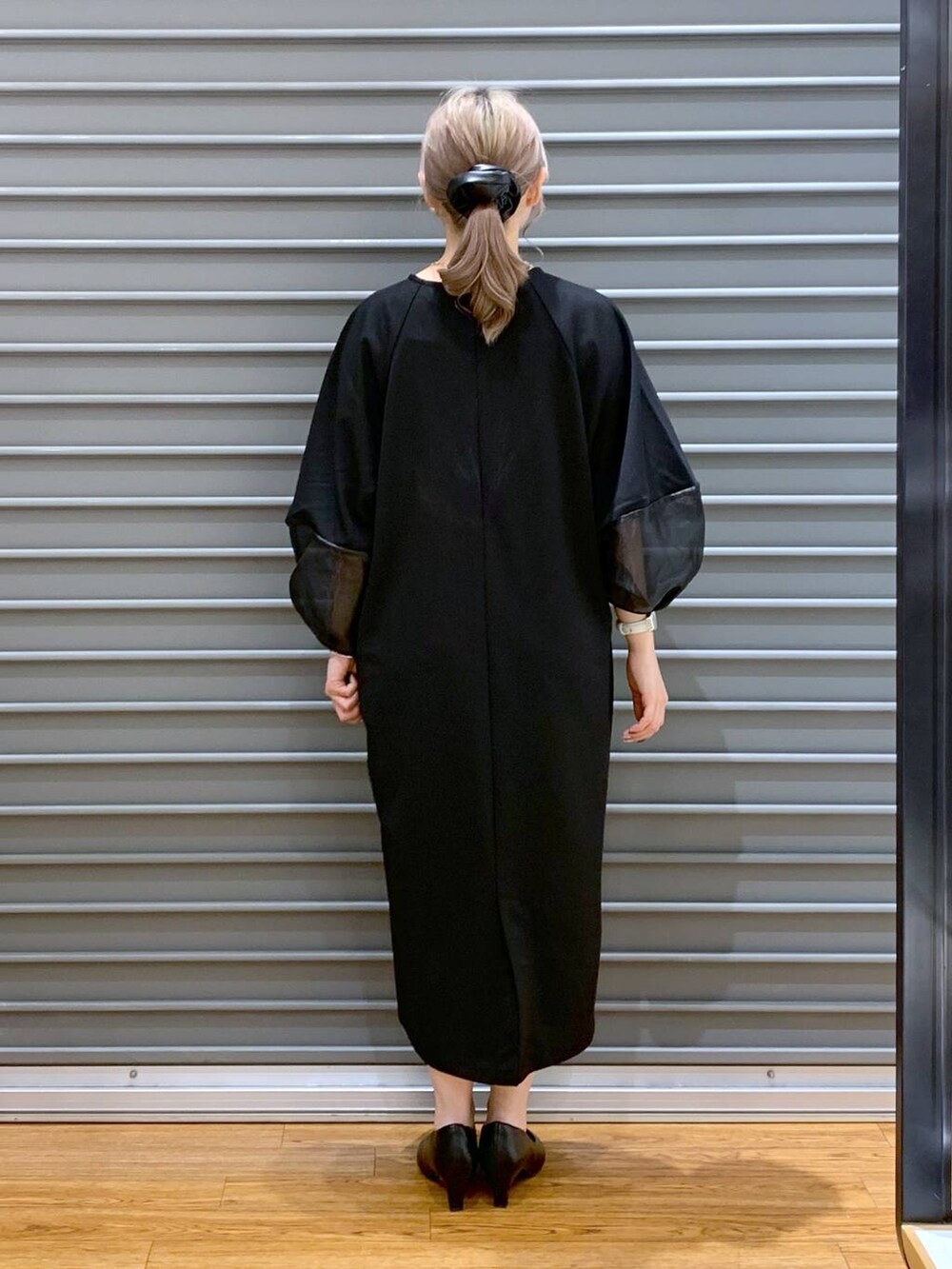 ブラック系のワンピース、ブラック系のパンプス、ブラック系のボストンバッグを着用したレディースの冬コーディネートの2枚目の写真