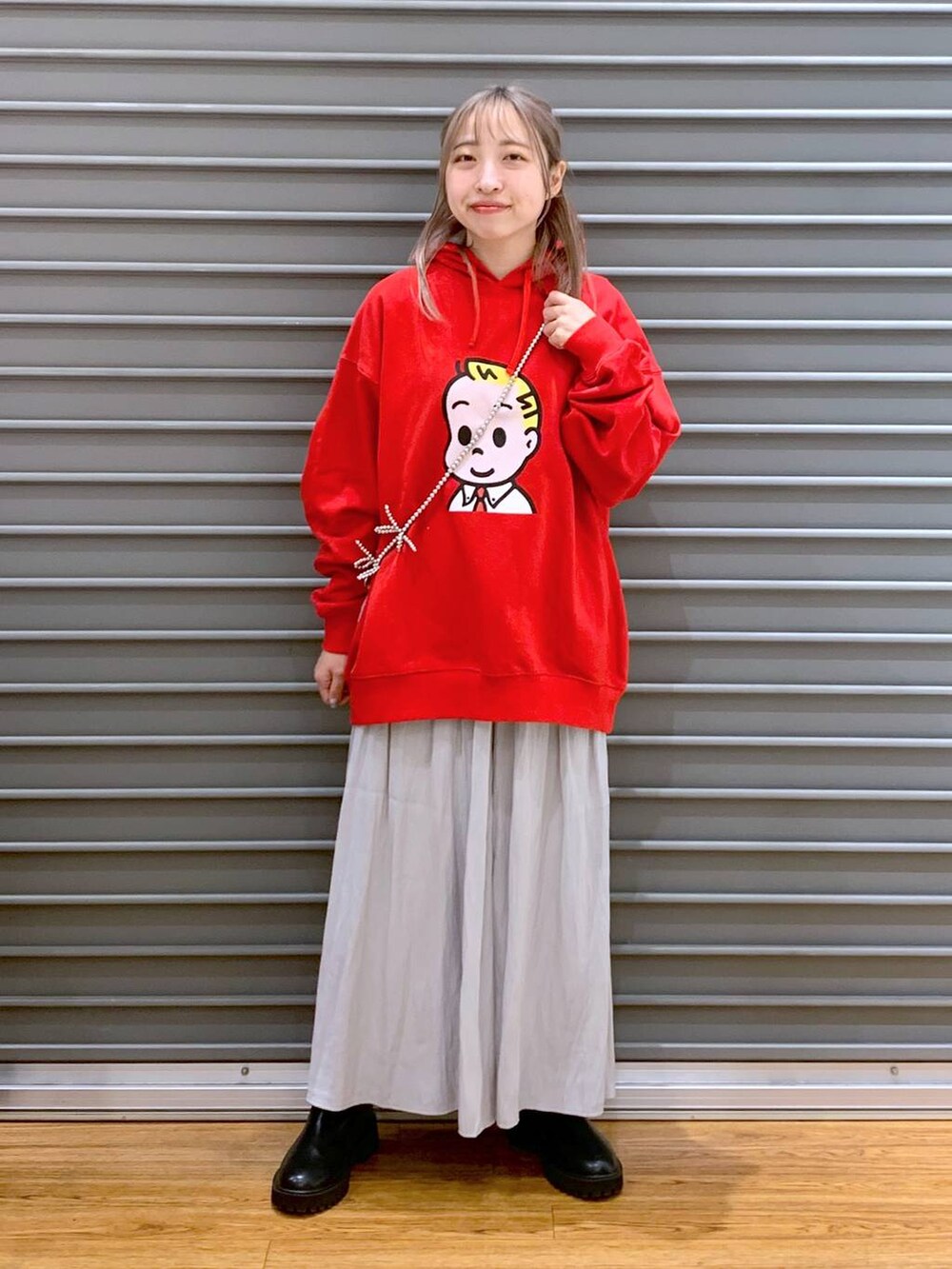 グレー系のその他パンツ、ブラック系のブーツ、レッド系のパーカーを着用したレディースの冬コーディネートの4枚目の写真