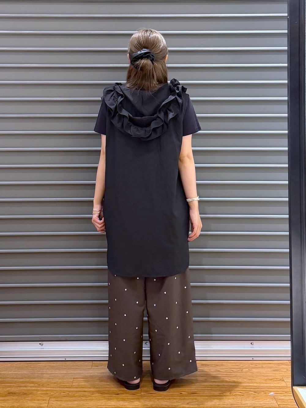 ブラック系のTシャツ/カットソー、ブラウン系のその他パンツ、ホワイト系のサンダルを着用したレディースの夏コーディネートの2枚目の写真