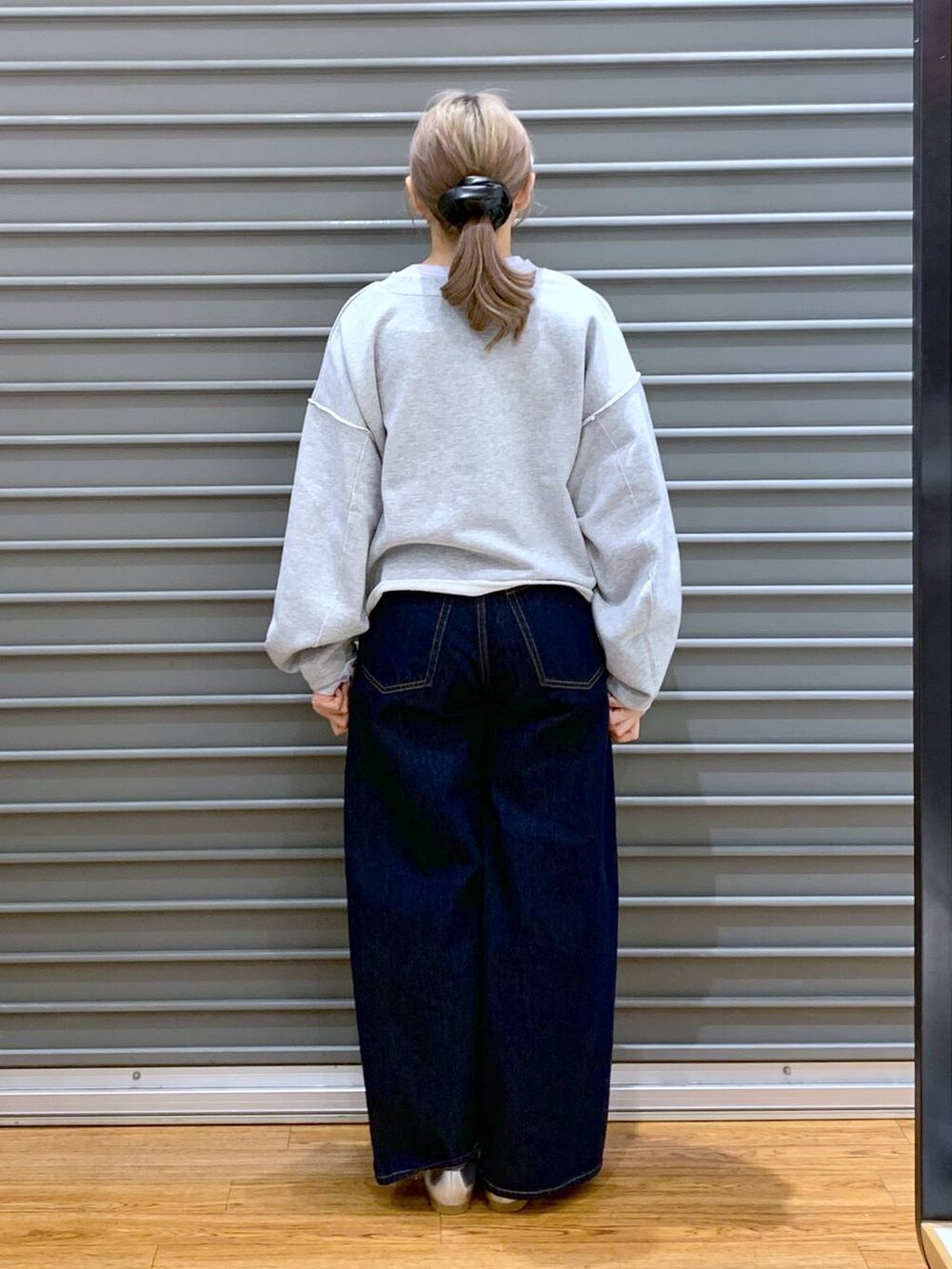 パープル系のTシャツ/カットソー、ブルー系のデニムパンツ、シルバー系のパンプスを着用したレディースの冬コーディネートの2枚目の写真