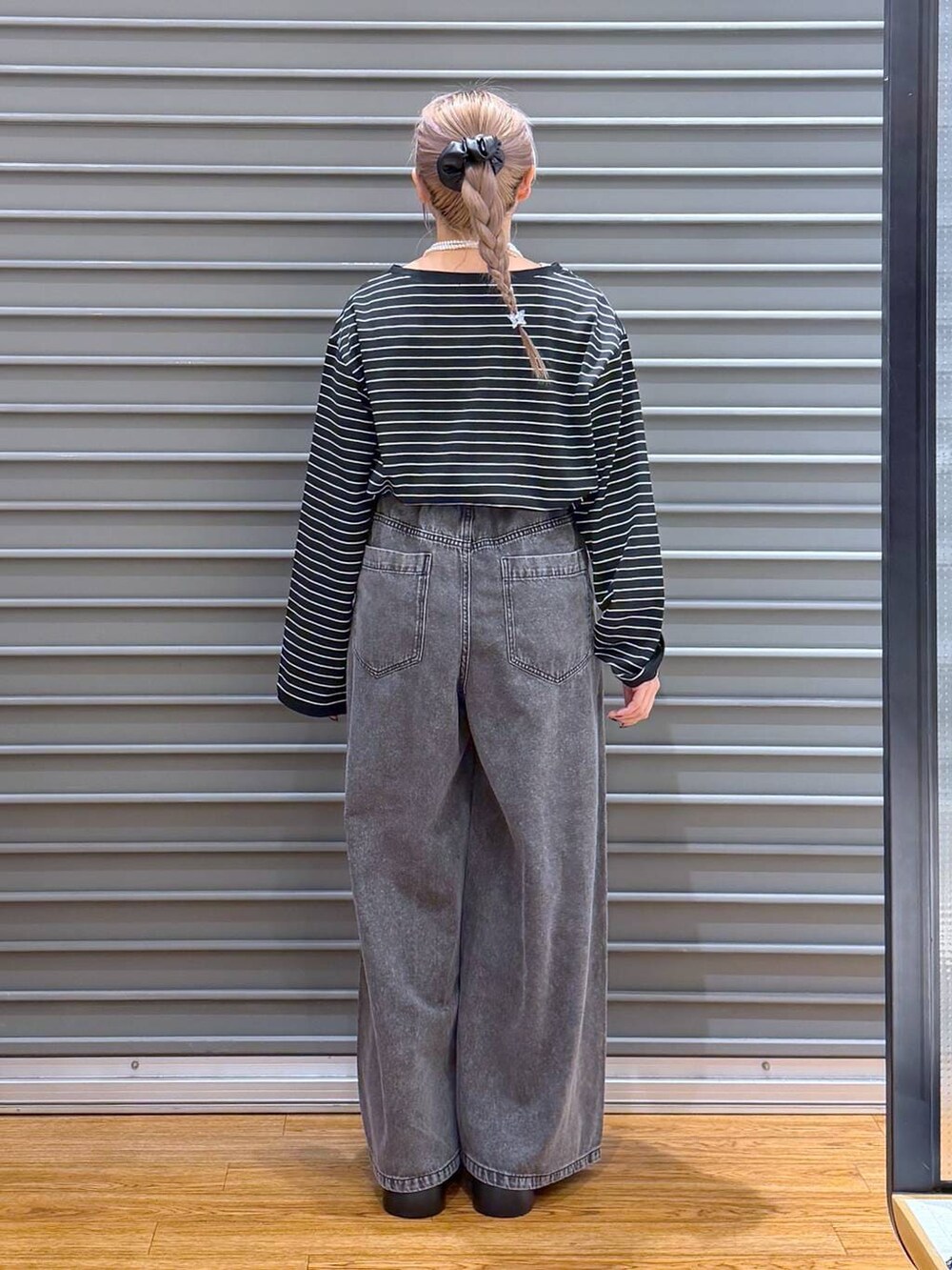 ブラック系のサンダル、グレー系のデニムパンツ、シルバー系のショルダーバッグを着用したレディースの冬コーディネートの3枚目の写真